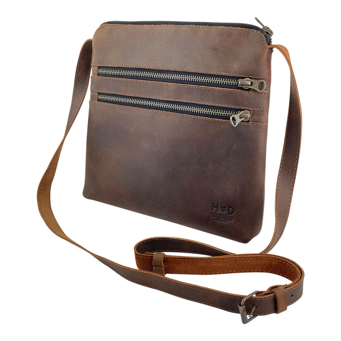 Side angle of the 3 Zipper Satchel by Hide & Drink, displaying the stylish dual zipper pockets. The perfect blend of functionality and fashion, this handbag is crafted from resilient materials. 3 Zipper Satchel - Versatile Handbag, Handmade from Full Grain Leather and Plaid Cotton, Small Batch Production, Hand Cut, Hand Sewn, Fire Branded, Artisan, Handmade in La Antigua Guatemala & Oaxaca Mexico.