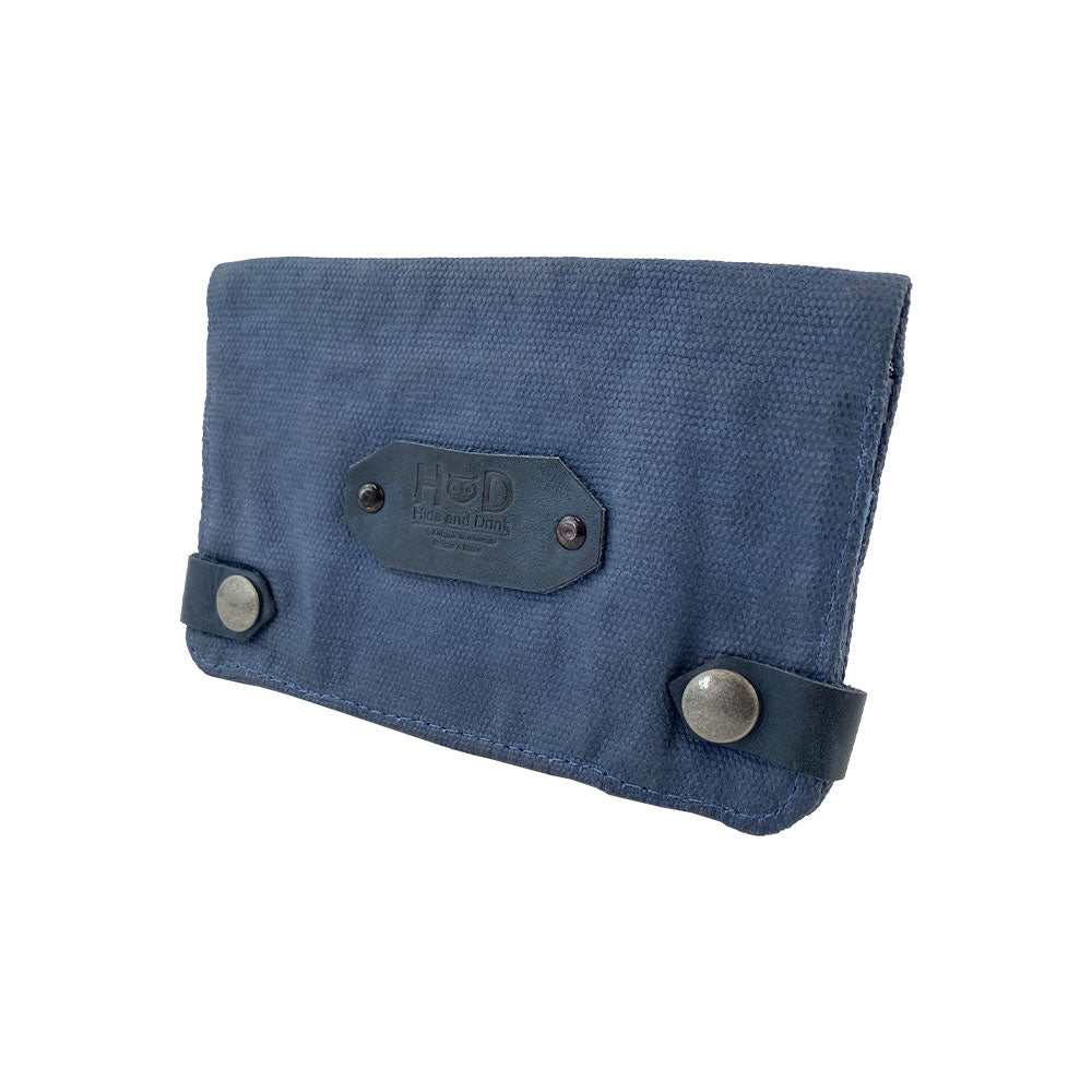 Side view of the blue Hide & Drink Tobacco Pouch Waxed Canvas, focusing on its sturdy and practical design. A must-have travel essential, this pouch combines functionality with artisanal craftsmanship for tobacco and accessories.