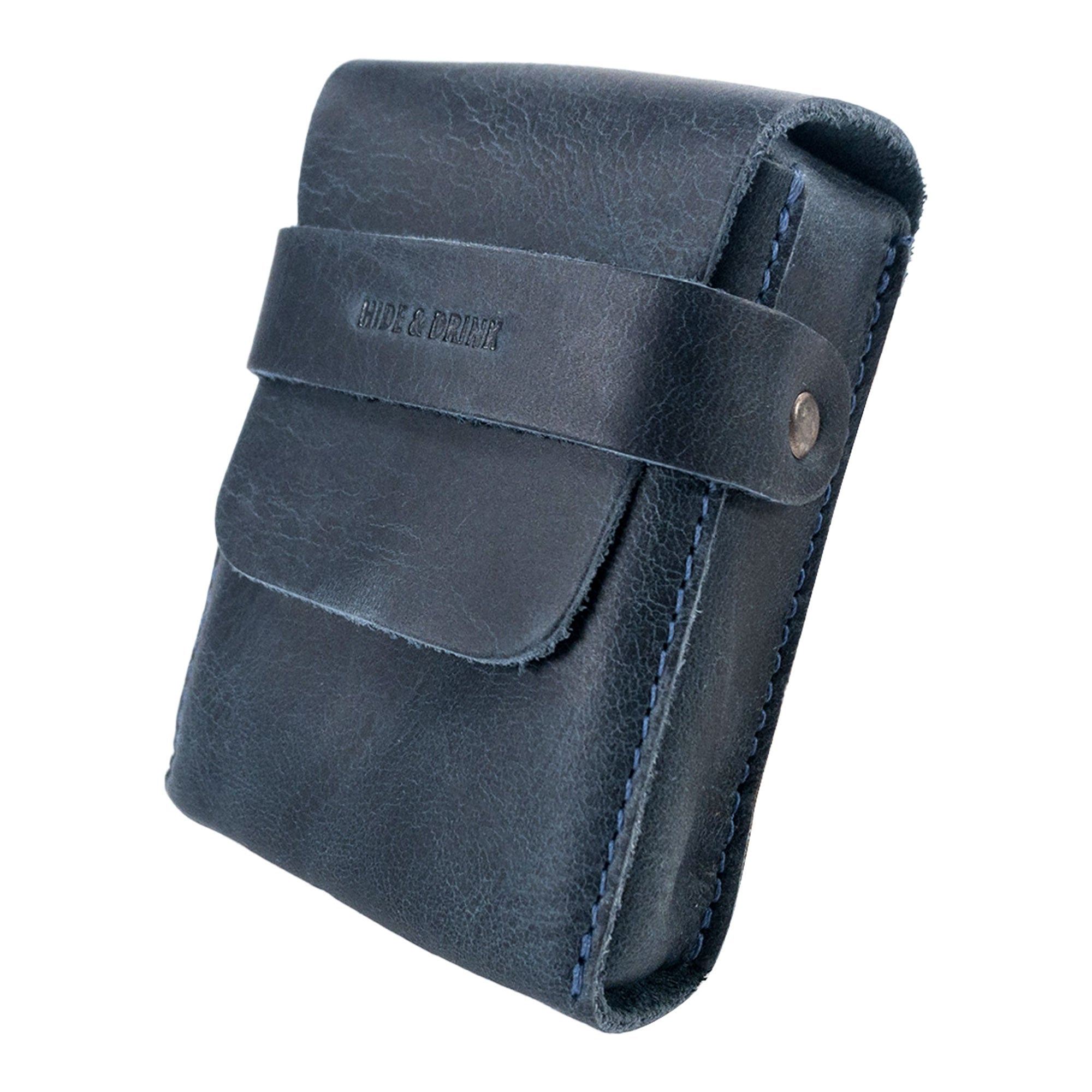 Side view of Hide & Drink's navy Playing Card Case emphasizing its stitching design. This travel accessory is ideal for securing your classic playing cards (not included) in a stylish package. Made from full grain leather, it embodies StockyardX's artisan craftsmanship.