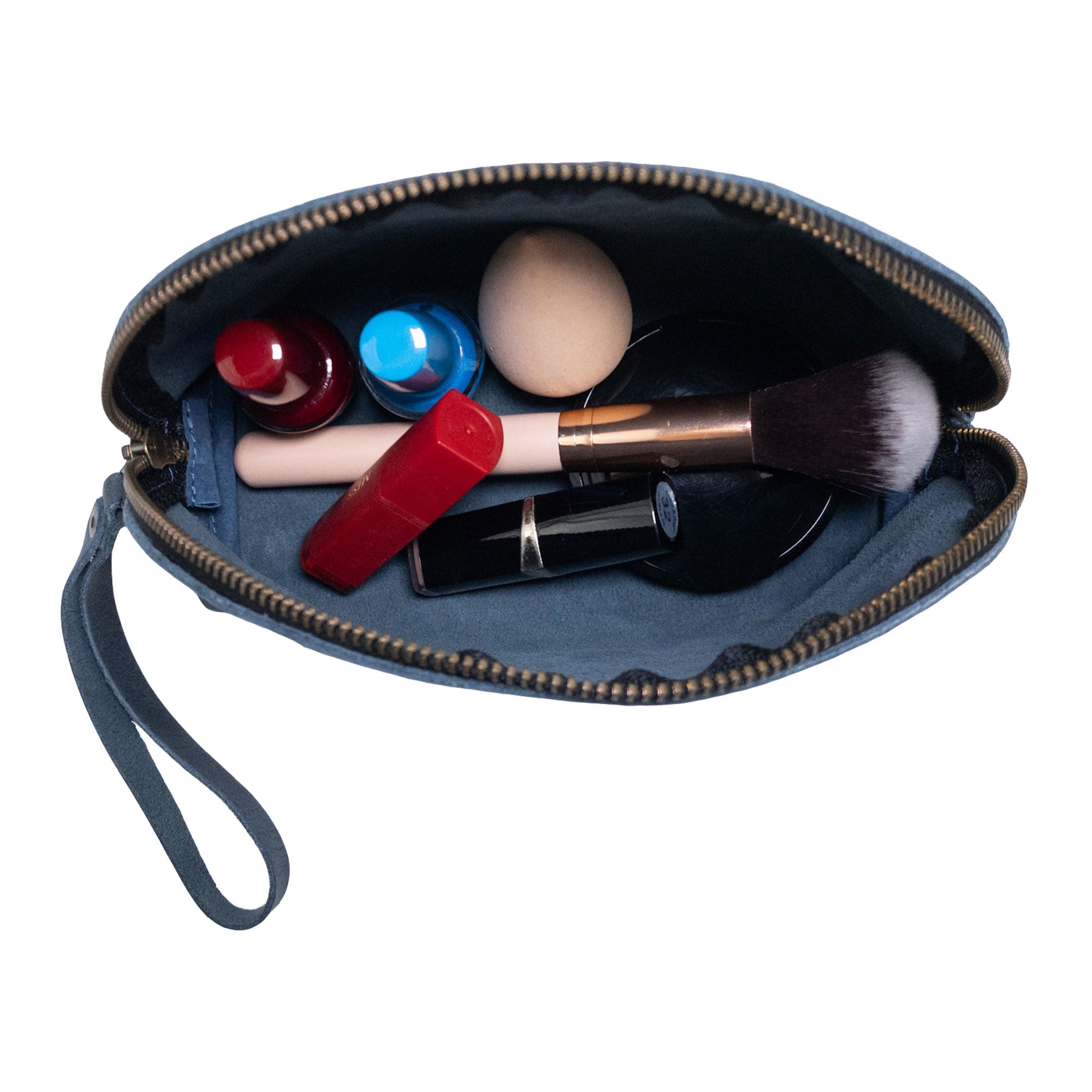 Inside view of the Accessory Pouch Organizer Hand Bag from Hide & Drink, filled with cosmetics and essentials. This Cosmetic Travel Organizer with Hand Strap for Women serves as an efficient Makeup Bag and Classic Handbag, handcrafted in small batches from La Antigua Guatemala & Oaxaca Mexico.