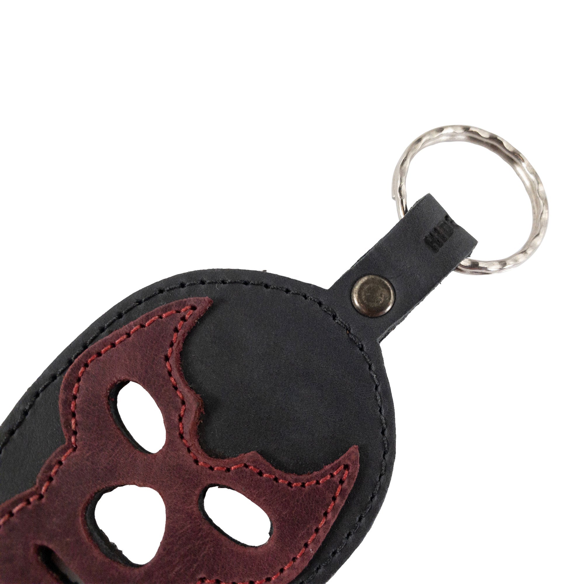 Close-up view of the Luchador Mask Leather Keychain showcasing the intricate detail on the leather, perfect for a personalized touch. This keyring by Hide & Drink is designed as a practical key organizer made from durable full grain leather, reflecting artisan craftsmanship with small batch production. Handmade in La Antigua Guatemala and Oaxaca Mexico.