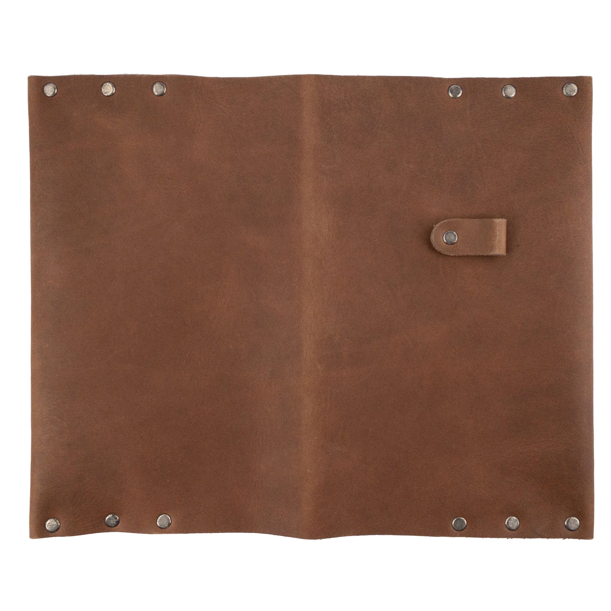 Flat lay of the Riveted Journal Cover (5 x 8.50 in.) by Hide & Drink, demonstrating the exterior design with its secure button closure. Crafted from full grain leather, this handmade piece offers a nostalgic vintage style suitable for custom notebooks, reflecting artisan skills from Guatemala and Mexico.