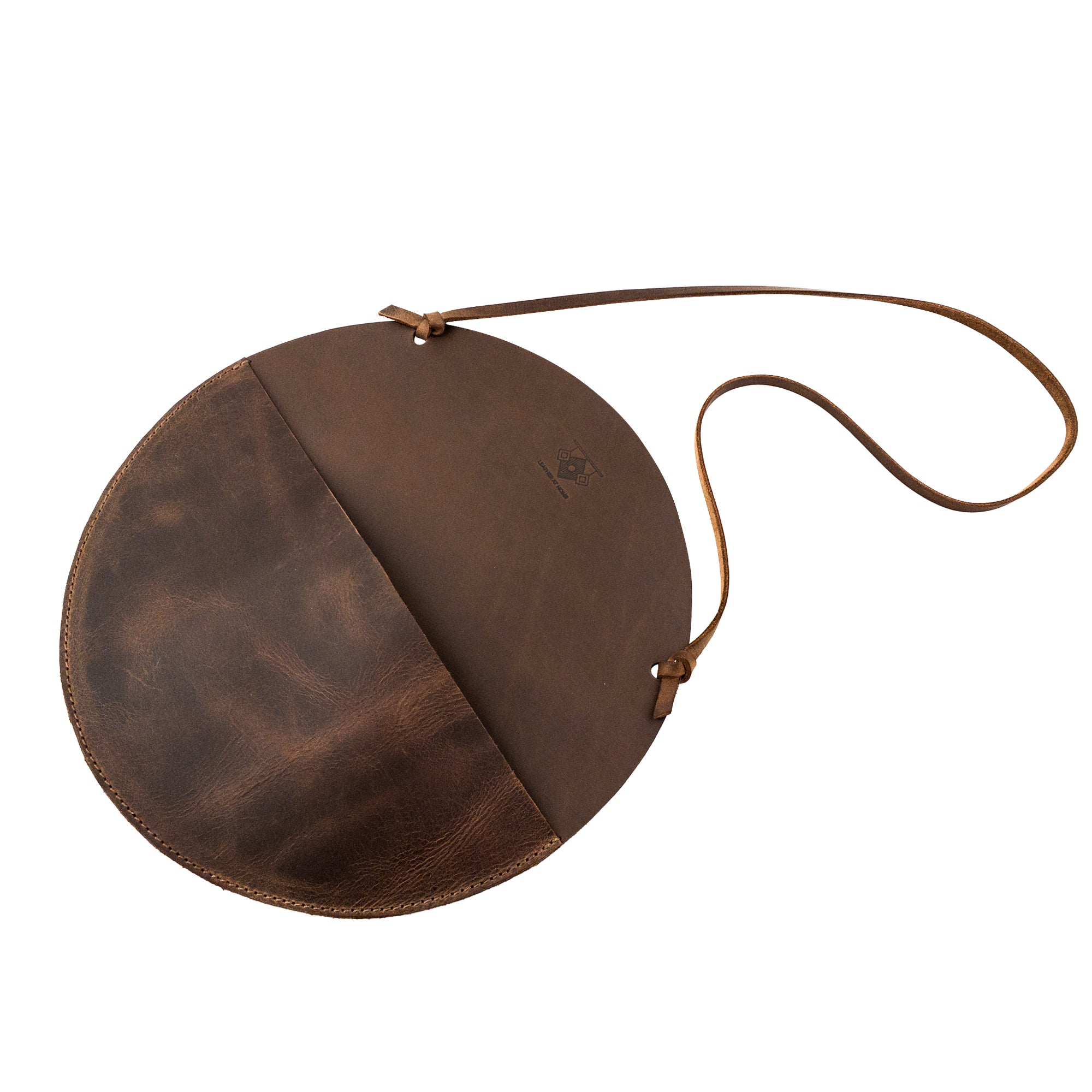Open view of the Leather At Home Circular Wall Hanger, displaying its spacious design for organizing letters and invoices. This handmade storage solution is made of full grain leather and emphasizes artisan-quality craftsmanship from Guatemala.