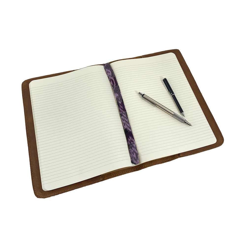 Open view of the interior of the patchwork leather Full Grain Leather Journal Cover for Moleskine Cahier XL (7.5 x 9.75 in.) by Hide & Drink, featuring a vibrant bookmark. A journal cover that combines creativity with practical design.