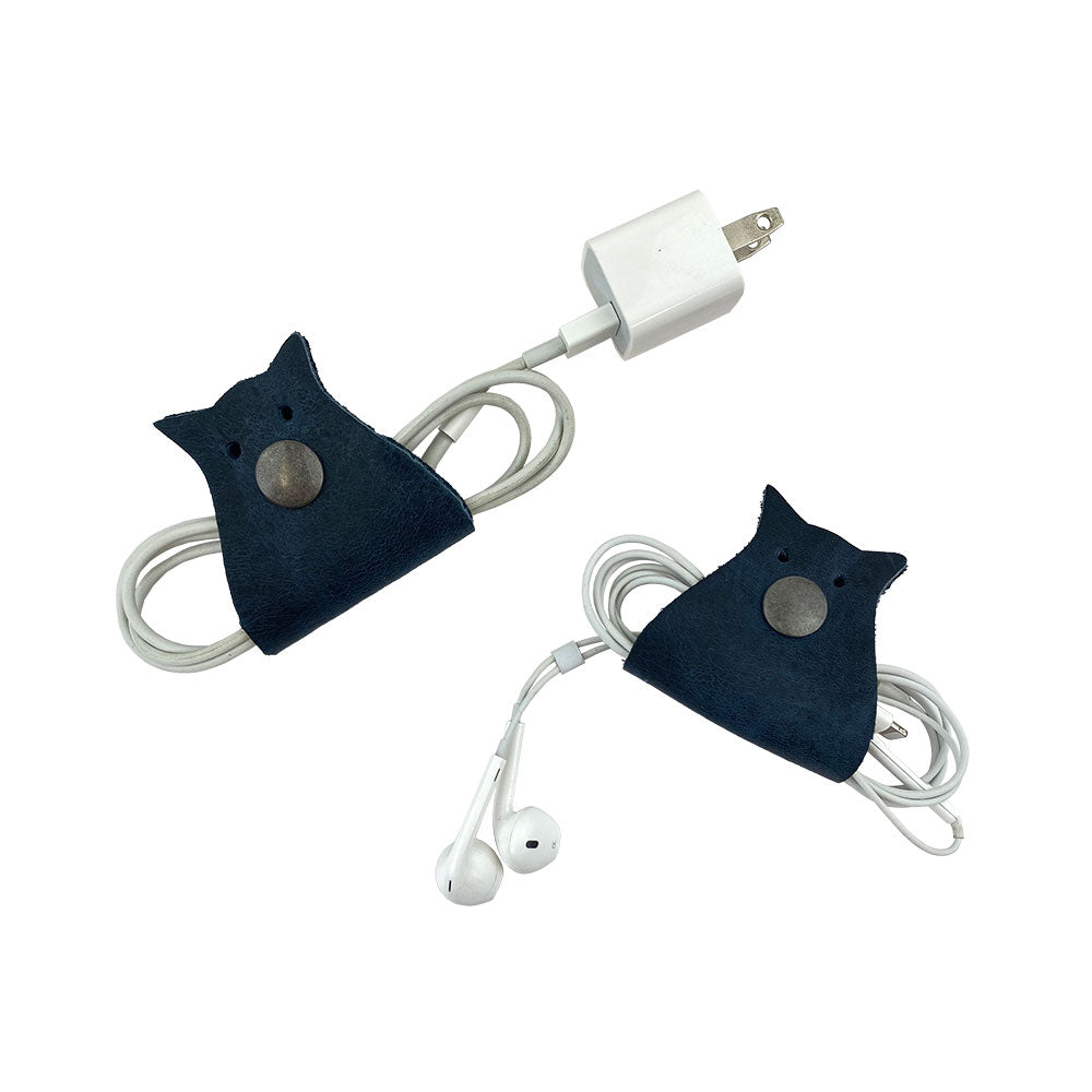 Owl Shaped Cord Keeper (2-Pack) by Hide & Drink showcasing cable organizers in dark blue with a practical design for seamless organization. Owl Shaped Cord Keeper (Cord Clam) 2-Pack. Full Grain Leather, StockyardX, Small Batch Production, Hand Cut, Hand Sewn, Fire Branded, Artisan, Handmade in La Antigua Guatemala & Oaxaca Mexico.