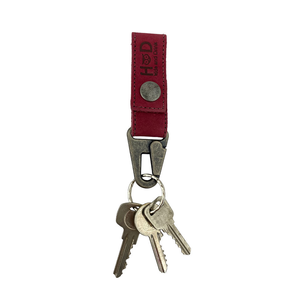 Hide & Drink Key Ring Holder in red leather with keys attached, showing its functionality and stylish design in everyday use. Key Ring Holder, Full Grain Leather, StockyardX, Small Batch Production, Hand Cut, Hand Sewn, Fire Branded, Artisan, Handmade in La Antigua Guatemala & Oaxaca Mexico.