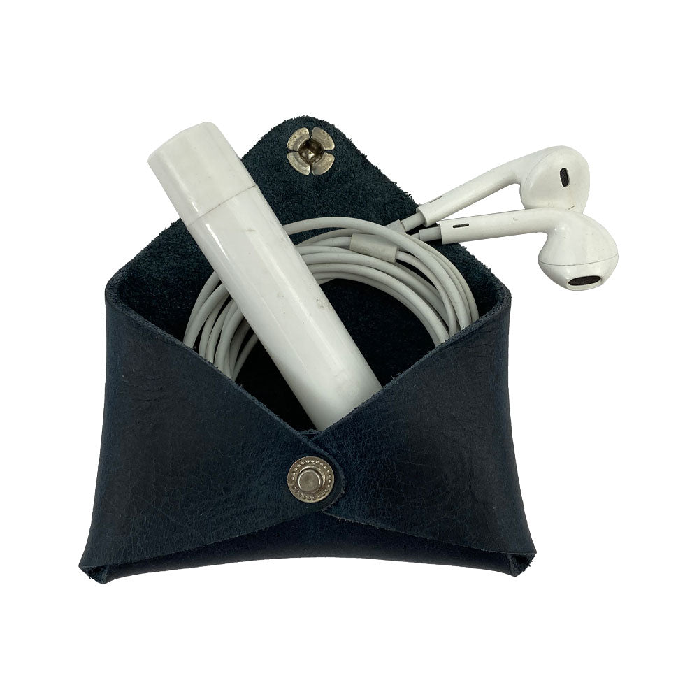 Hide & Drink Envelope Coin Case with earphones inside, illustrating its stylish versatility. Crafted from full grain leather, this rustic leather item is handmade in La Antigua Guatemala & Oaxaca Mexico.