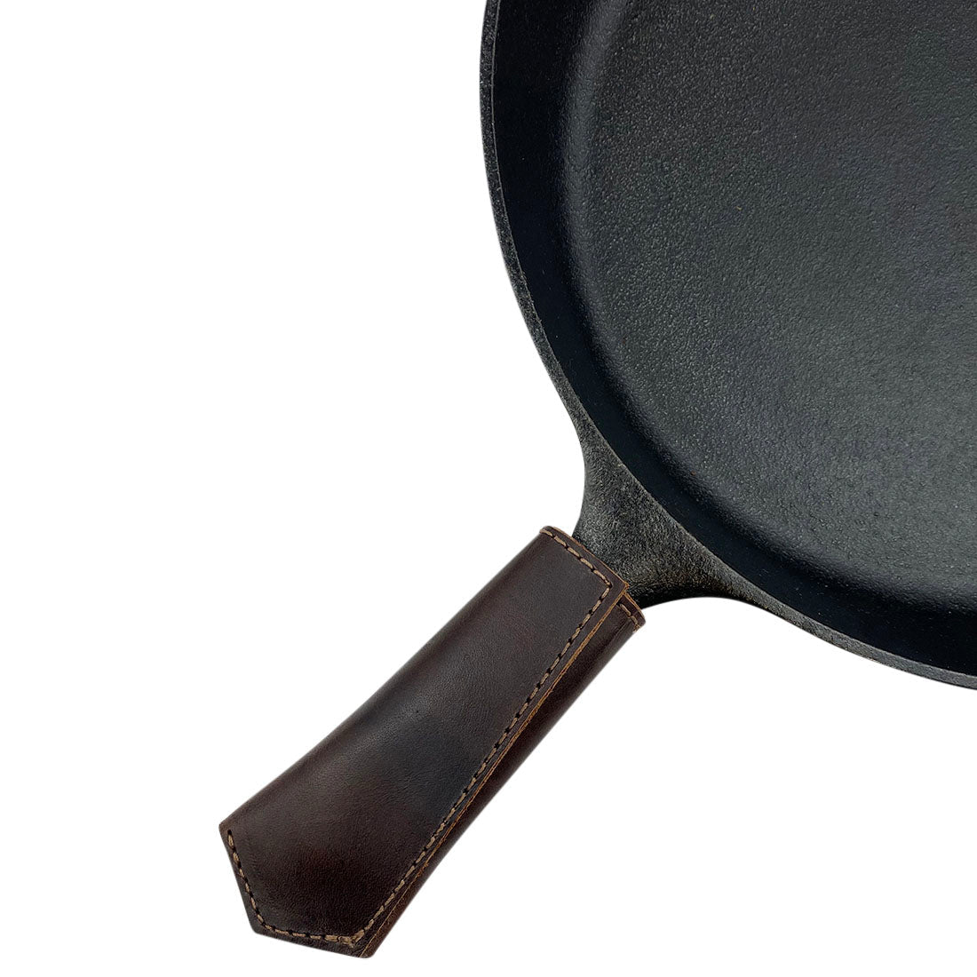 Hide & Drink Hot Pan Handle Cover fitted on a cast iron skillet, highlighting its practical use and stylish design. This handcrafted item is made from full grain leather, representing small batch production and artisan quality from La Antigua Guatemala & Oaxaca Mexico.