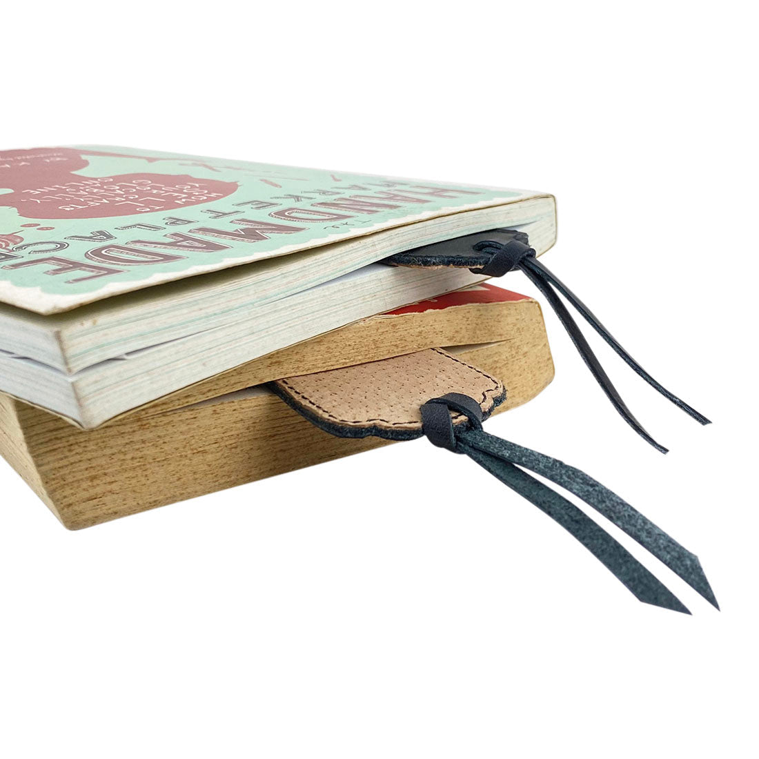 Deluxe Long Bookmark (2 Pack) from Hide & Drink, displaying two leather bookmarks in a stacked position. This stylish reversible page marker makes a great classic accessory for book or journal lovers, crafted from full grain leather, emphasizing stockyardX, small batch production, hand cut, hand sewn, fire branded, artisan quality, handmade in La Antigua Guatemala & Oaxaca Mexico.
