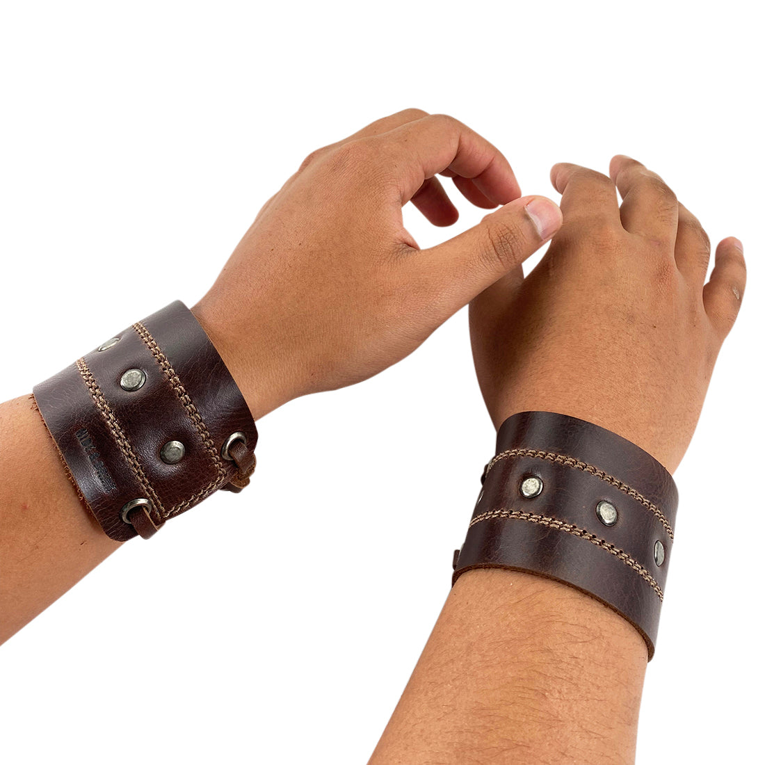 A model wearing the Men's Wristband by Hide & Drink, illustrating its adjustable fit and stylish appearance on the wrist. This handmade full grain leather bracelet is a versatile accessory that elevates any casual look. Men's Wristband Handmade, Full Grain Leather, StockyardX, Small Batch Production, Hand Cut, Hand Sewn, Fire Branded, Artisan, Handmade in La Antigua Guatemala & Oaxaca Mexico.