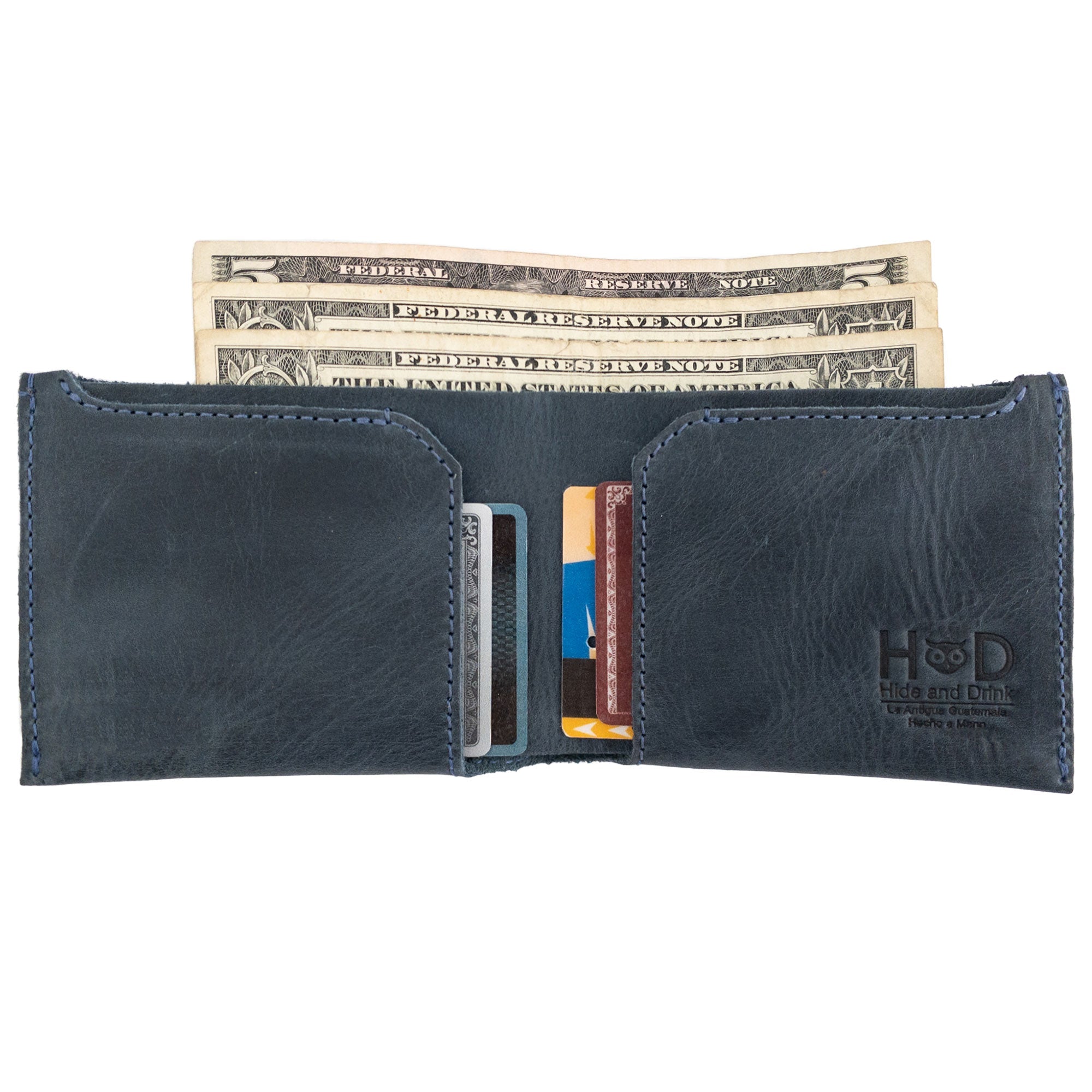 Close-up of the navy blue Hide & Drink Classic Wallet with cards inside, illustrating its capacity as a convenient card organizer. Classic Wallet, Card Organizer, Money Holder, Vintage Pocket, Travel Accessories, Full Grain Leather, StockyardX, Small Batch Production, Hand Cut, Hand Sewn, Fire Branded, Artisan, Handmade in La Antigua Guatemala & Oaxaca Mexico.