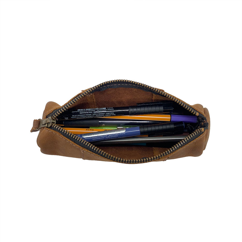 Utility Cylinder Case by Hide & Drink filled with pens, demonstrating its use for office supplies and personal items. This handmade bag features a rustic design and Full Grain Leather craftsmanship. Cylinder Case, Classic Bag, Handmade, Rustic.
