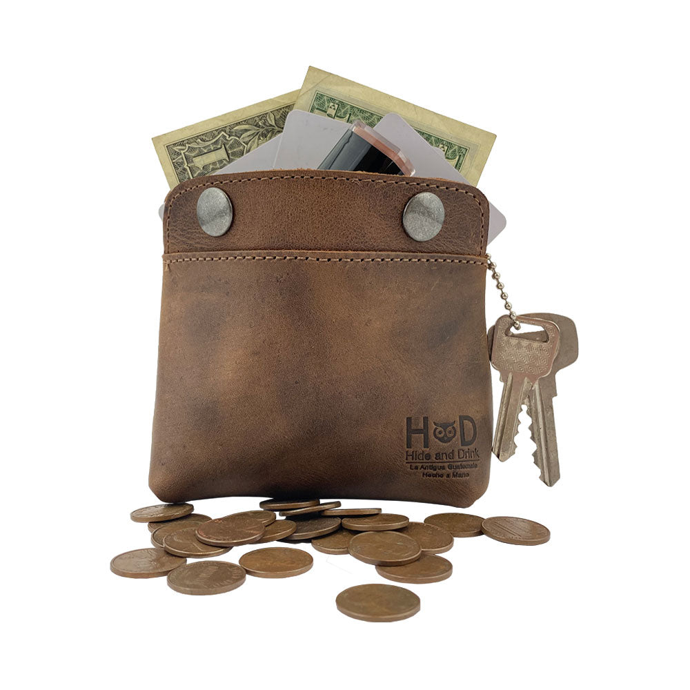 Hide & Drink Double Snap Pouch filled with cash and coins, great for use as a coin purse or cash & card holder. This artisan-made full grain leather product is a handmade treasure from La Antigua Guatemala, ideal for cables or makeup.