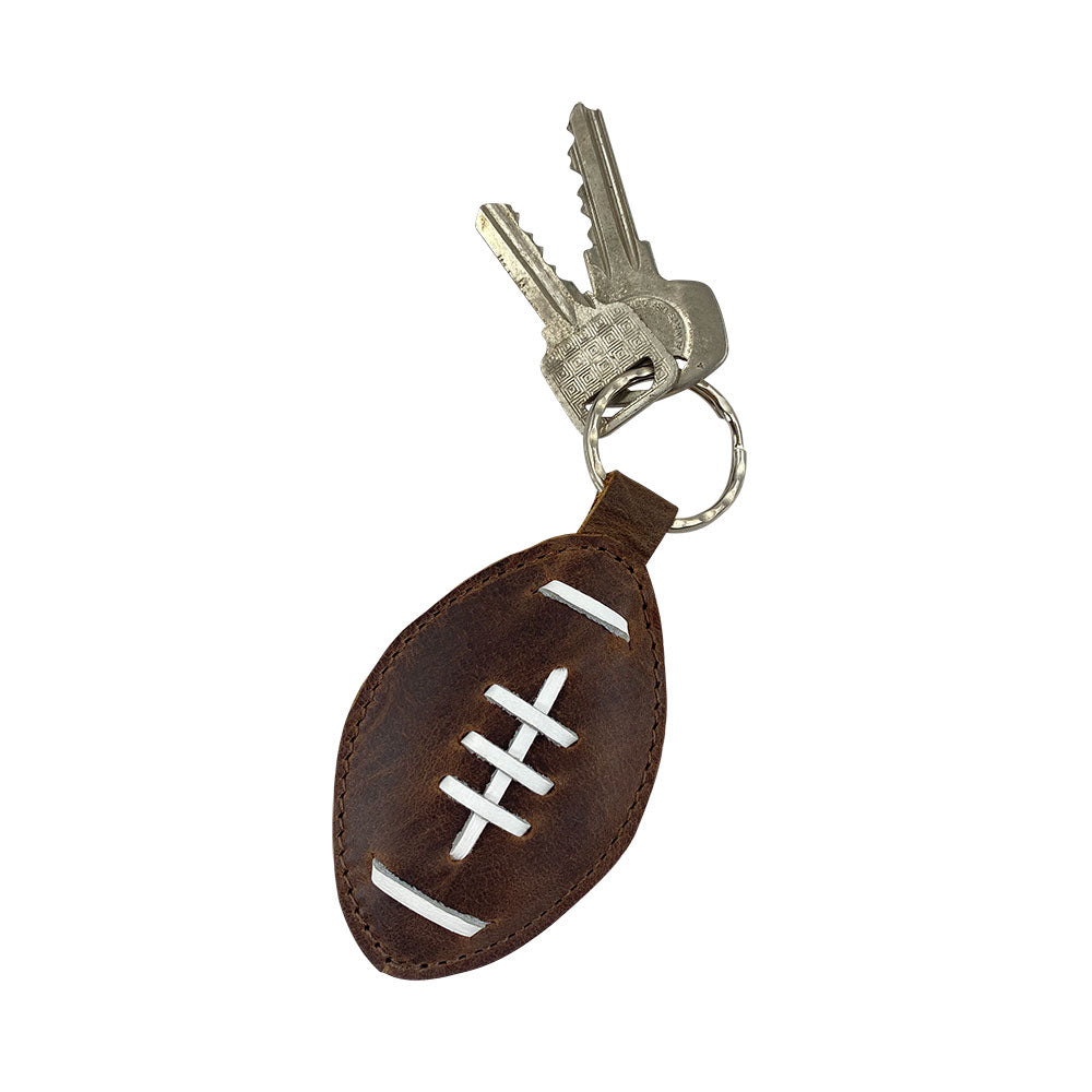 Football Key Chain by Hide & Drink attached to keys, demonstrating its practical use and stylish design in Full Grain Leather. A must-have for sports enthusiasts with tags Football Keychain, Small Batch Production, Hand Cut, Hand Sewn, Fire Branded, Artisan, Handmade in La Antigua Guatemala & Oaxaca Mexico.