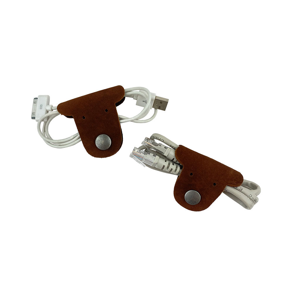 Two brown Dog Shaped Cord Keepers neatly organizing USB cables, showcasing the craftsmanship of Hide & Drink's Full Grain Leather products. Dog Shaped Cord Keeper (Cord Clam) 2-Pack, Full Grain Leather, StockyardX, Small Batch Production, Hand Cut, Hand Sewn, Fire Branded, Artisan, Handmade in La Antigua Guatemala & Oaxaca Mexico.