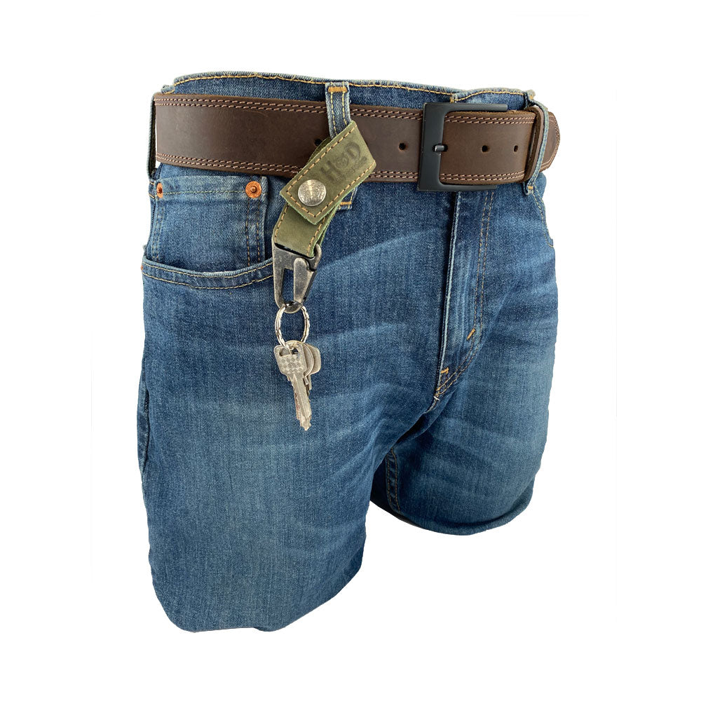 Stylish Key Ring Holder from Hide & Drink, made of Full Grain Leather, showcasing a rustic aesthetic while being securely attached to denim shorts. Key Ring Holder, Full Grain Leather, StockyardX, Small Batch Production, Hand Cut, Hand Sewn, Fire Branded, Artisan, Handmade in La Antigua Guatemala & Oaxaca Mexico.