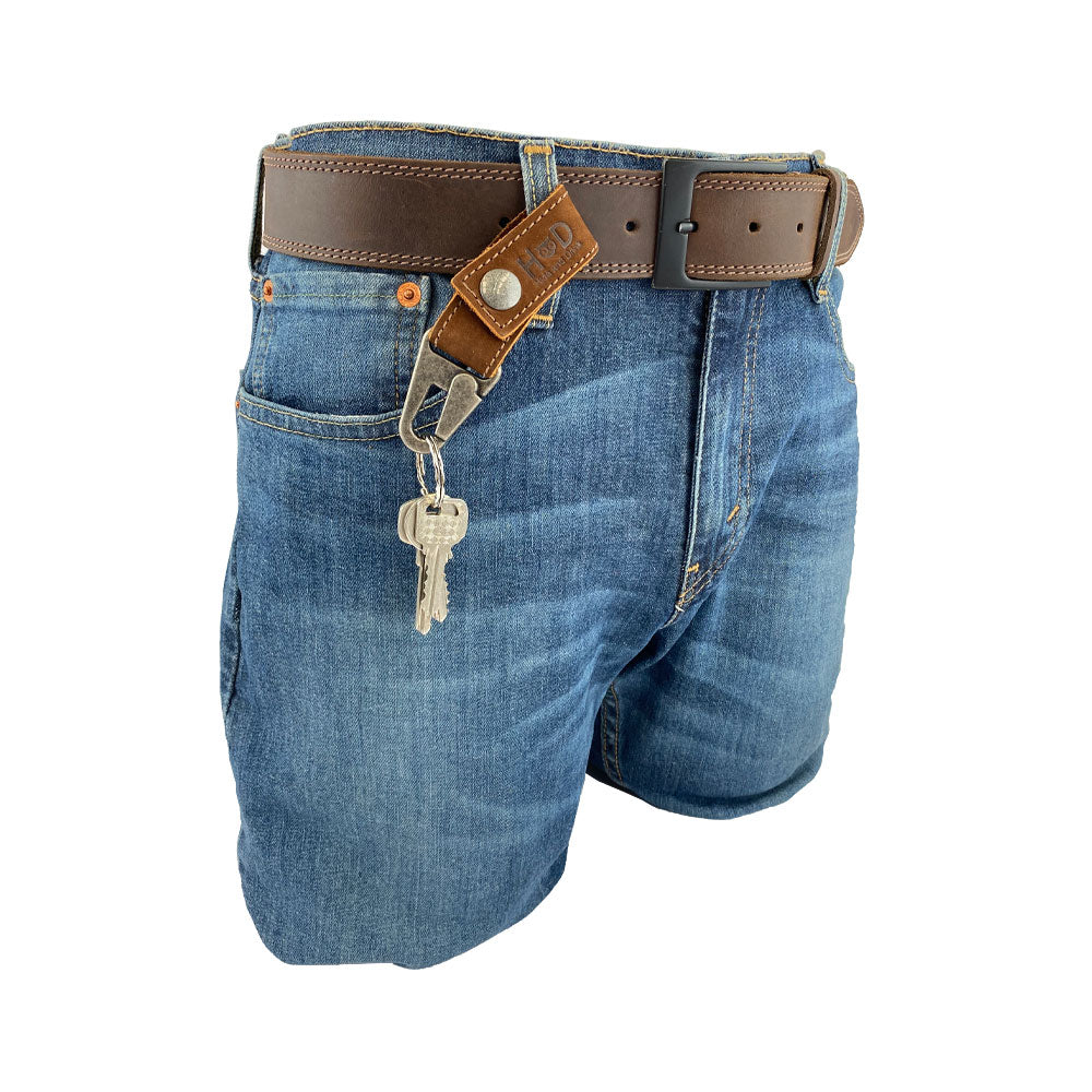 Key Ring Holder from Hide & Drink elegantly displayed on a belt. Crafted with Full Grain Leather, this piece emphasizes Small Batch Production and is Hand Cut and Hand Sewn. Artisan quality from La Antigua Guatemala & Oaxaca Mexico.