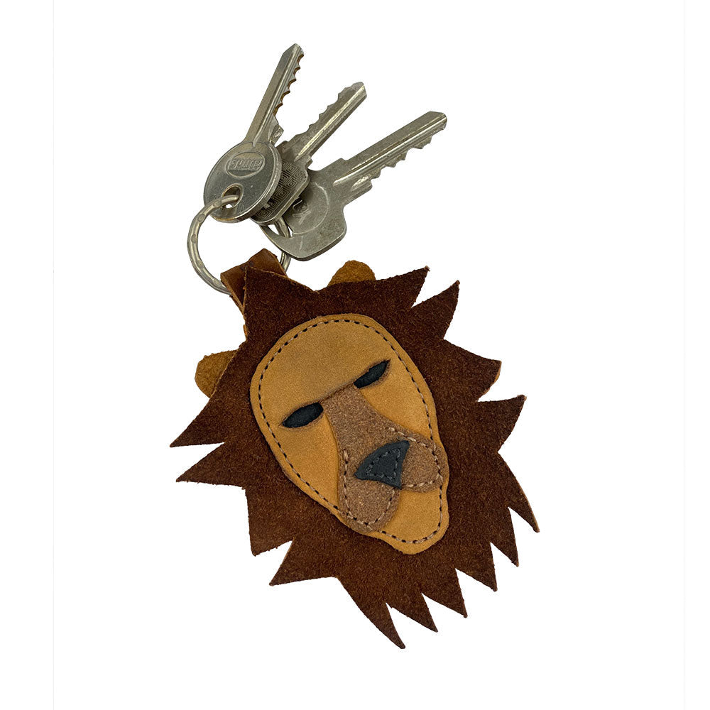 Lion Keychain by Hide & Drink, featuring a vibrant lion face with suede leather design, held alongside keys. This handmade key ring combines traditional artisan techniques from La Antigua Guatemala & Oaxaca Mexico, reflecting the spirit of the zodiac sign Leo.