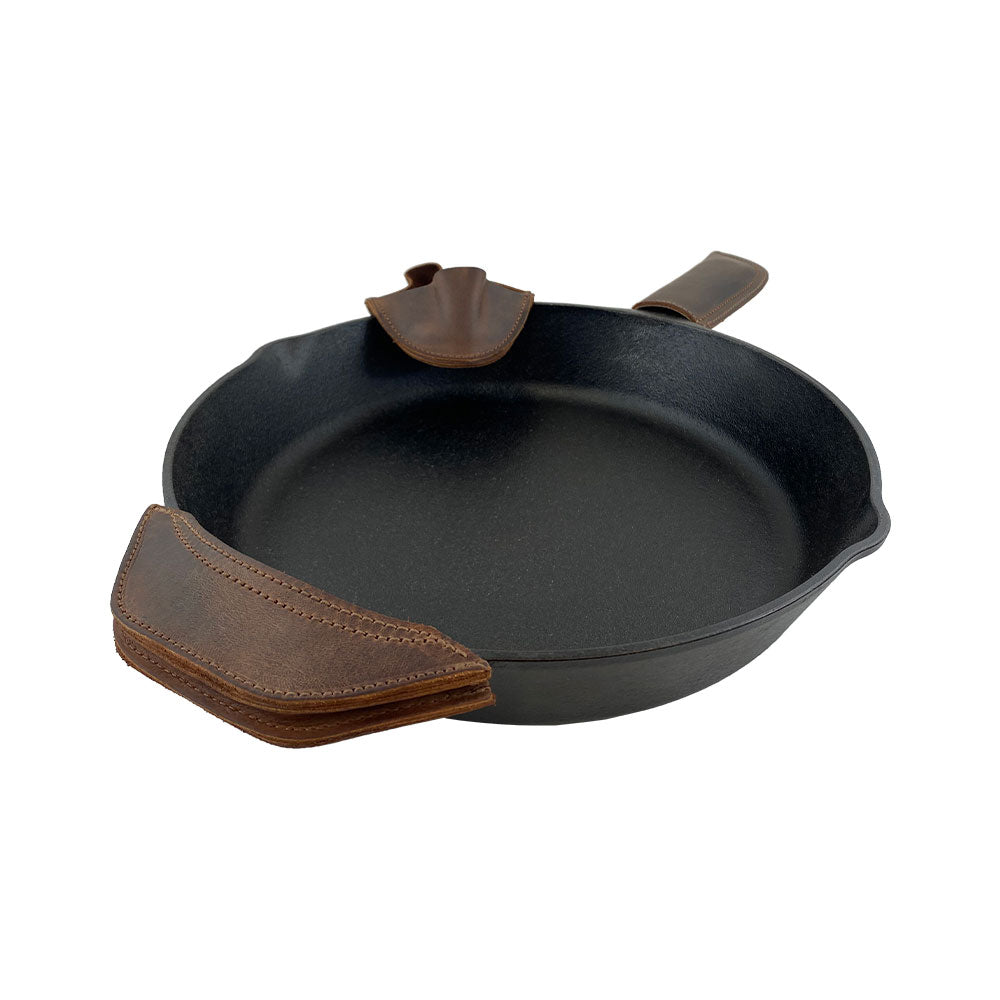 A close-up view of the stunning 3 Rustic Hot Handle Holders by Hide & Drink, demonstrating the craftsmanship in the Panhandle, Side Kick, and Grip Mitt. Perfect for handling hot cast iron skillets, this set is made from Full Grain Leather with attention to Small Batch Production, featuring items that are Hand Cut and Hand Sewn by artisans in La Antigua Guatemala & Oaxaca Mexico.