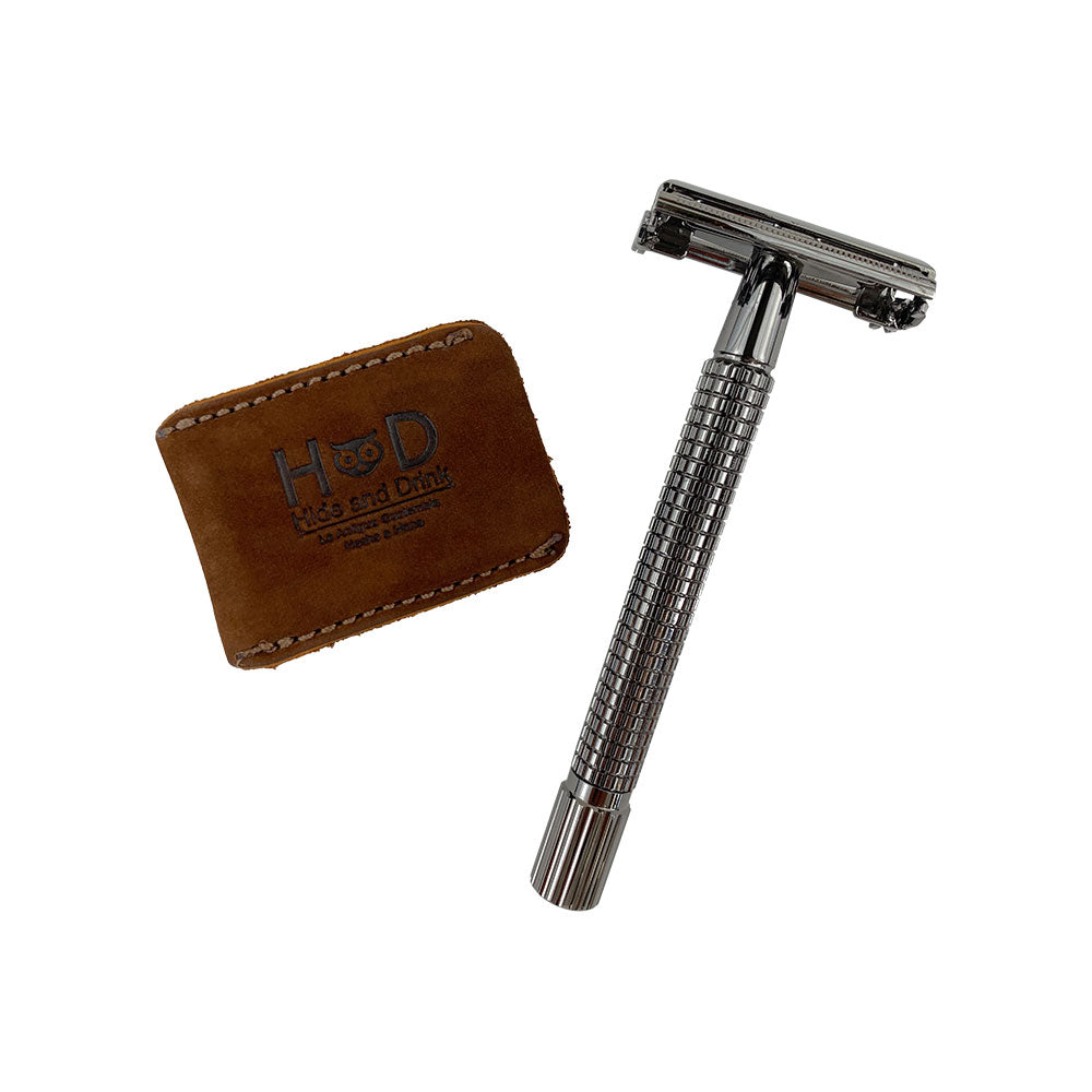 The Razor Head Cover by Hide & Drink displayed alongside a double edge safety razor. This full grain leather protective sheath serves as a stylish shaving travel cover, combining artisan skills with small batch production. Hand cut, hand sewn, and fire branded, it's a perfect blend of craftsmanship from La Antigua Guatemala & Oaxaca Mexico.