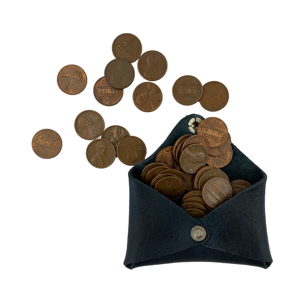 Hide & Drink Envelope Coin Case filled with coins, demonstrating its practicality and charm. This artisan product is made from high-quality full grain leather and handcrafted in La Antigua Guatemala & Oaxaca Mexico.