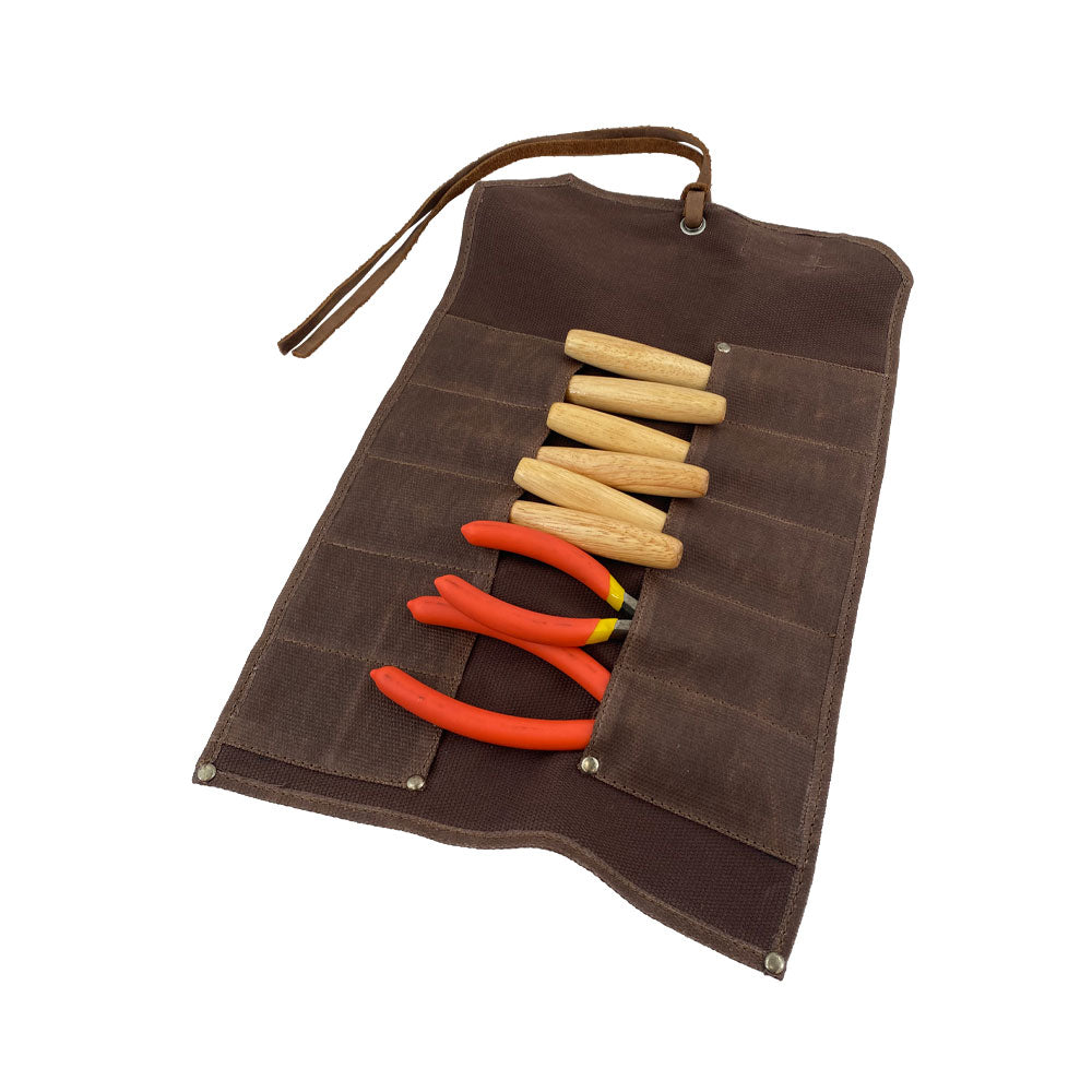 Hide & Drink Tool Roll offers a practical small tool roll-up bag with 10 slots, crafted from fine full grain leather. Perfect as a portable carry-on pouch, it organizes woodworking tools, enhancing your workshop storage capacity. Each artisan piece is handmade in La Antigua Guatemala & Oaxaca Mexico, emphasizing craftsmanship.