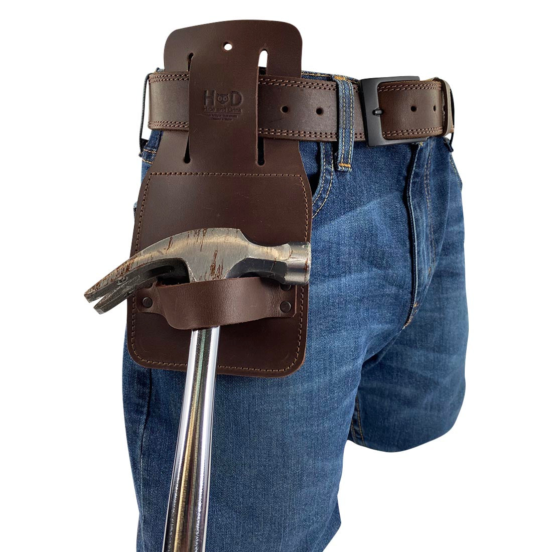 Men's jeans with Hide & Drink's Hammer Holster attached at the waist, illustrating its convenience. This Hammer Holster for Belt is a durable accessory for tools, made from full grain leather, hand cut and sewn for artisan quality, perfect for effortless tool access.