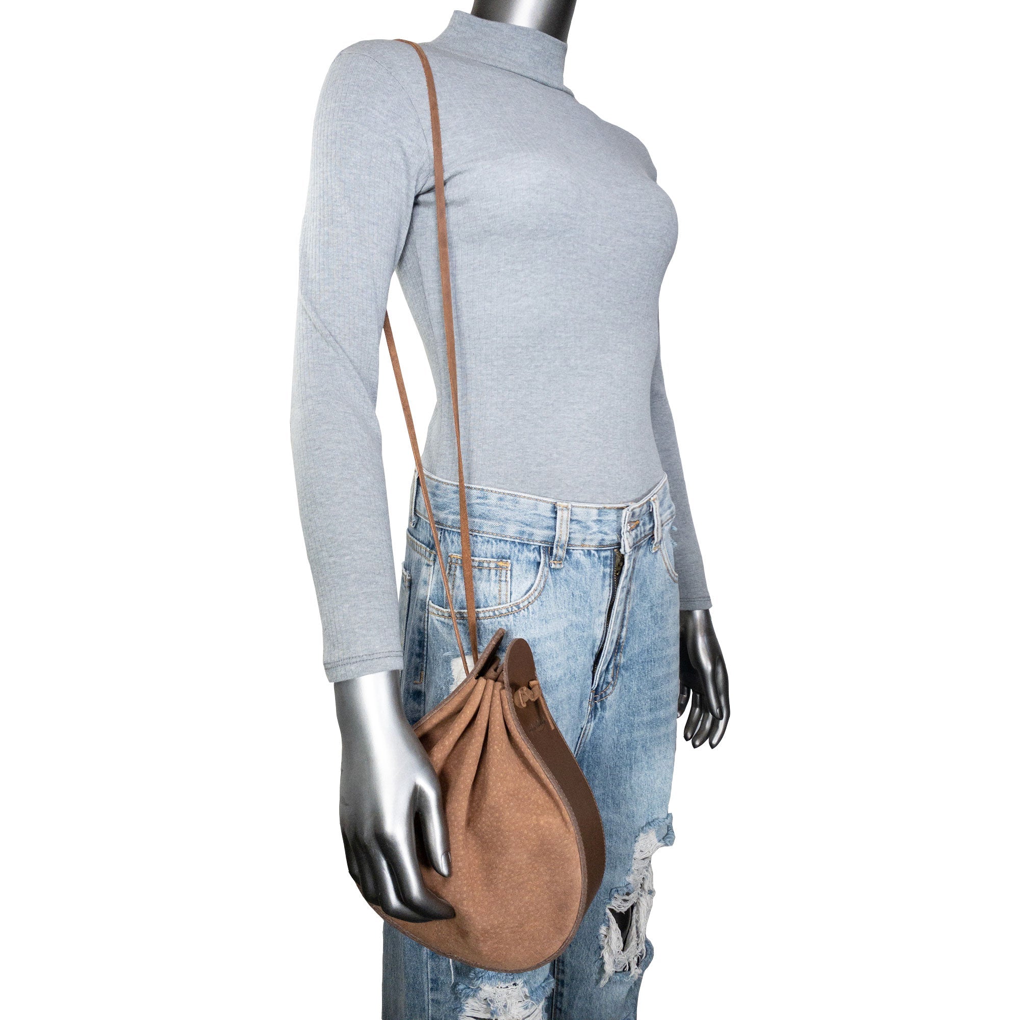 Model showcasing Heather's Shoulder Bag worn as a multipurpose rounded shoulder bag. This full grain leather bag is perfect for travel and features a strap for easy carrying. With its artisan craftsmanship, achieved through small batch production, hand cut and hand sewn techniques, this bag is fire branded to highlight its quality, handmade in La Antigua Guatemala & Oaxaca Mexico.