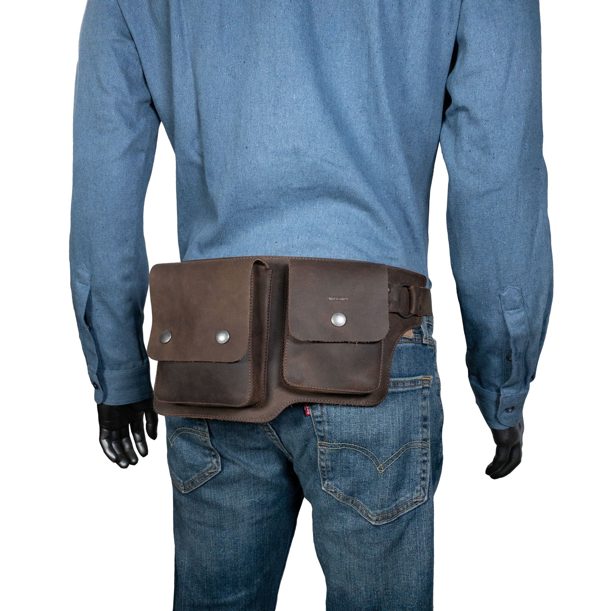 A model wearing the Hide & Drink Rectangular Waist Bag, demonstrating its stylish fit and practicality. This Waist Bag with Adjustable Belt is an ideal outdoor accessory, serving as a great tool holder for camping, crafted from high-quality Full Grain Leather. It's small batch production showcases hand-cut, hand-sewn artisan craftsmanship made in La Antigua Guatemala & Oaxaca Mexico.