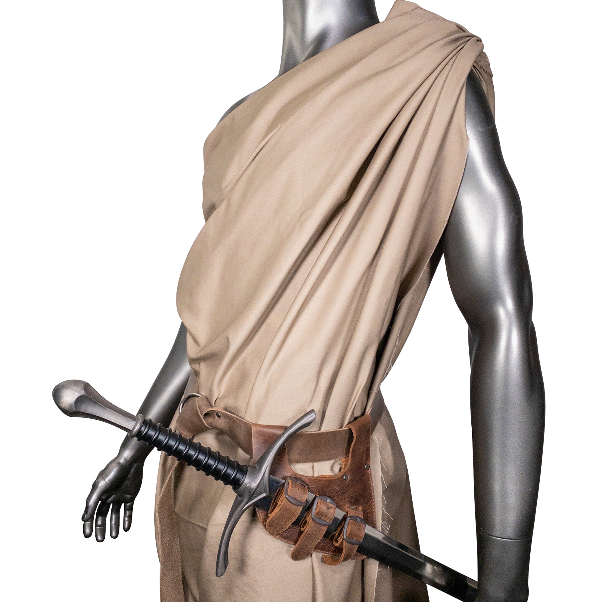 A model showcasing the Medieval Sword Holder with 3 Buckles from Hide & Play, complete with a sword, designed from durable Full Grain Leather. This piece combines function and style, making it an excellent choice for Fantasy Cosplay and a Historical Costume Accessory. Crafted through Small Batch Production, each piece is Hand Cut, Hand Sewn, and Fire Branded, embodying the skill of artisans in La Antigua Guatemala & Oaxaca Mexico.