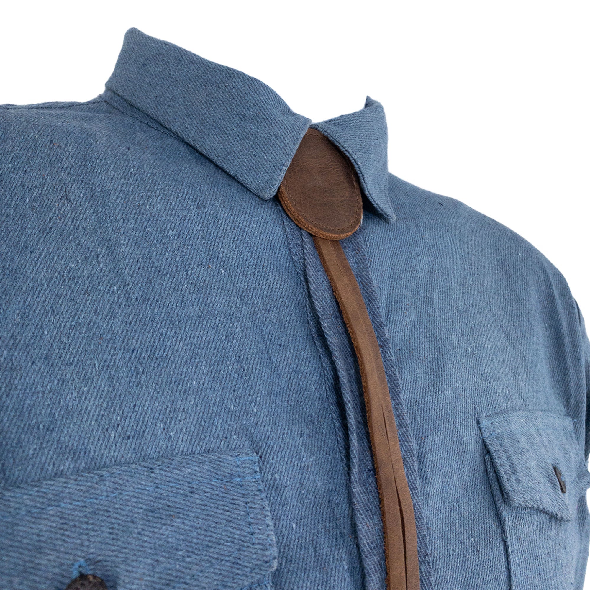 Cowboy Bolo Tie from Western Leather Works styled on a shirt, highlighting its round shape and made from full grain leather. A durable necktie costume accessory showcasing small batch production and artisan craftsmanship, handmade in La Antigua Guatemala & Oaxaca Mexico.