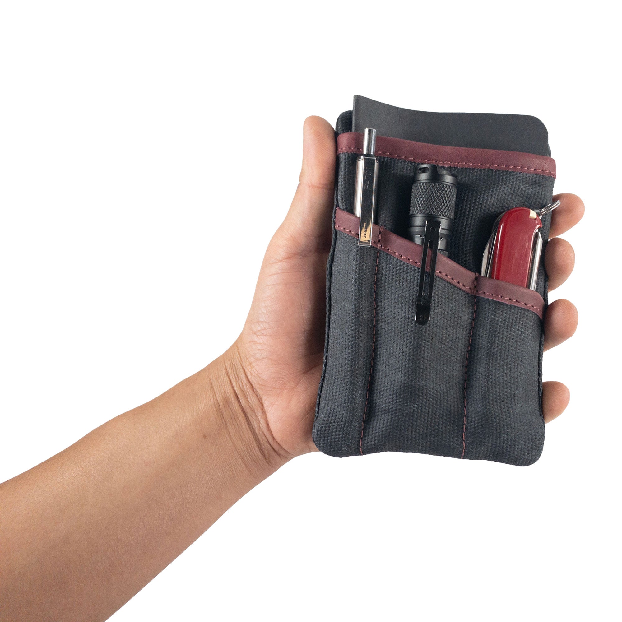 Person holding the teal Multi-tool Pocket Pouch by Hide & Drink, showcasing its effectiveness as an EDC tool organizer.
