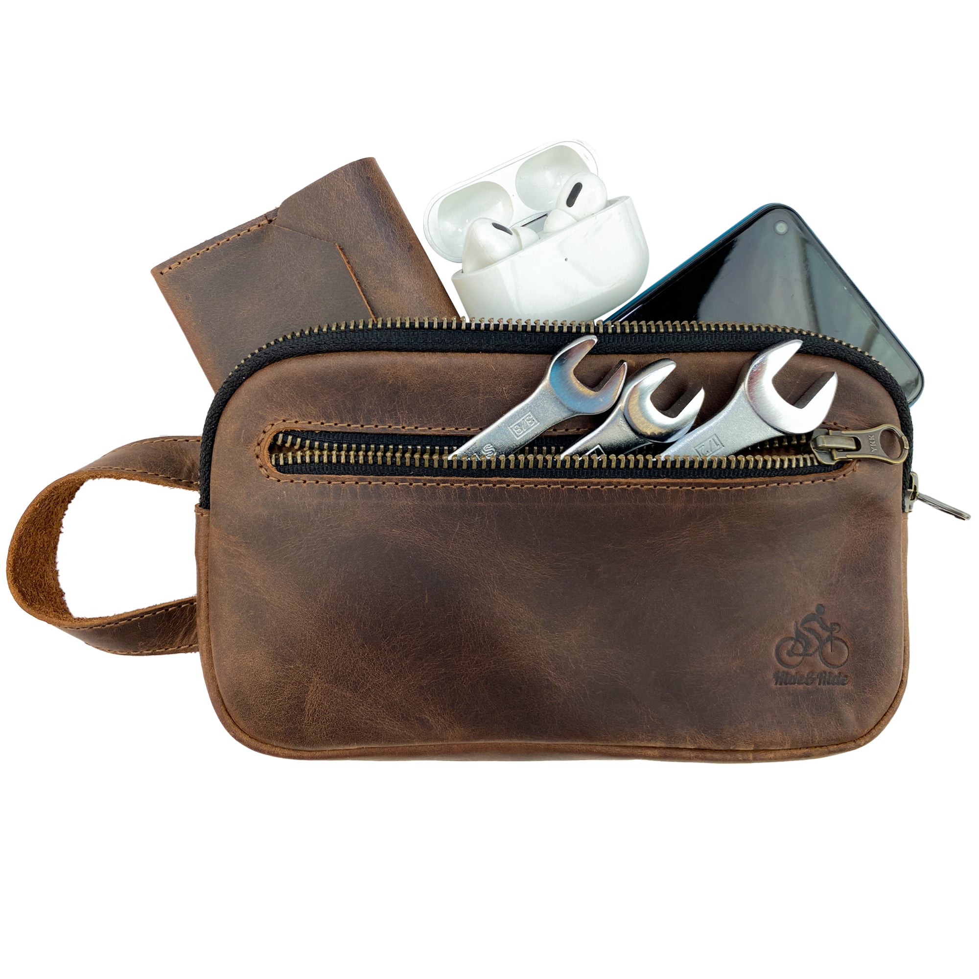 Hide & Ride Cycling Phone Bag filled with tools and personal items, accentuating its role as a practical utility bag. The durable full grain leather design is perfect for cyclists and is handmade in La Antigua Guatemala, balancing quality and aesthetics.