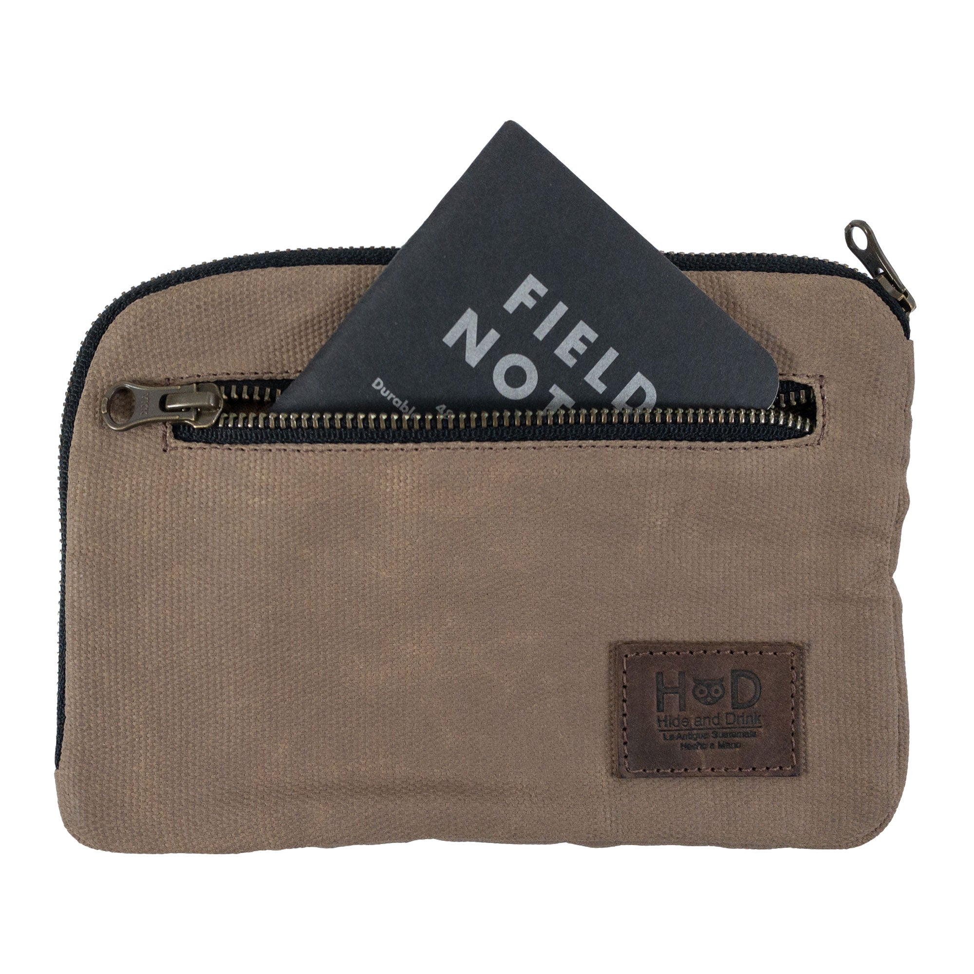 Hide & Drink's brown Zipper Gear Pouch with a Field Notes card, illustrating its practical design for organization and handmade quality from water resistant waxed canvas.