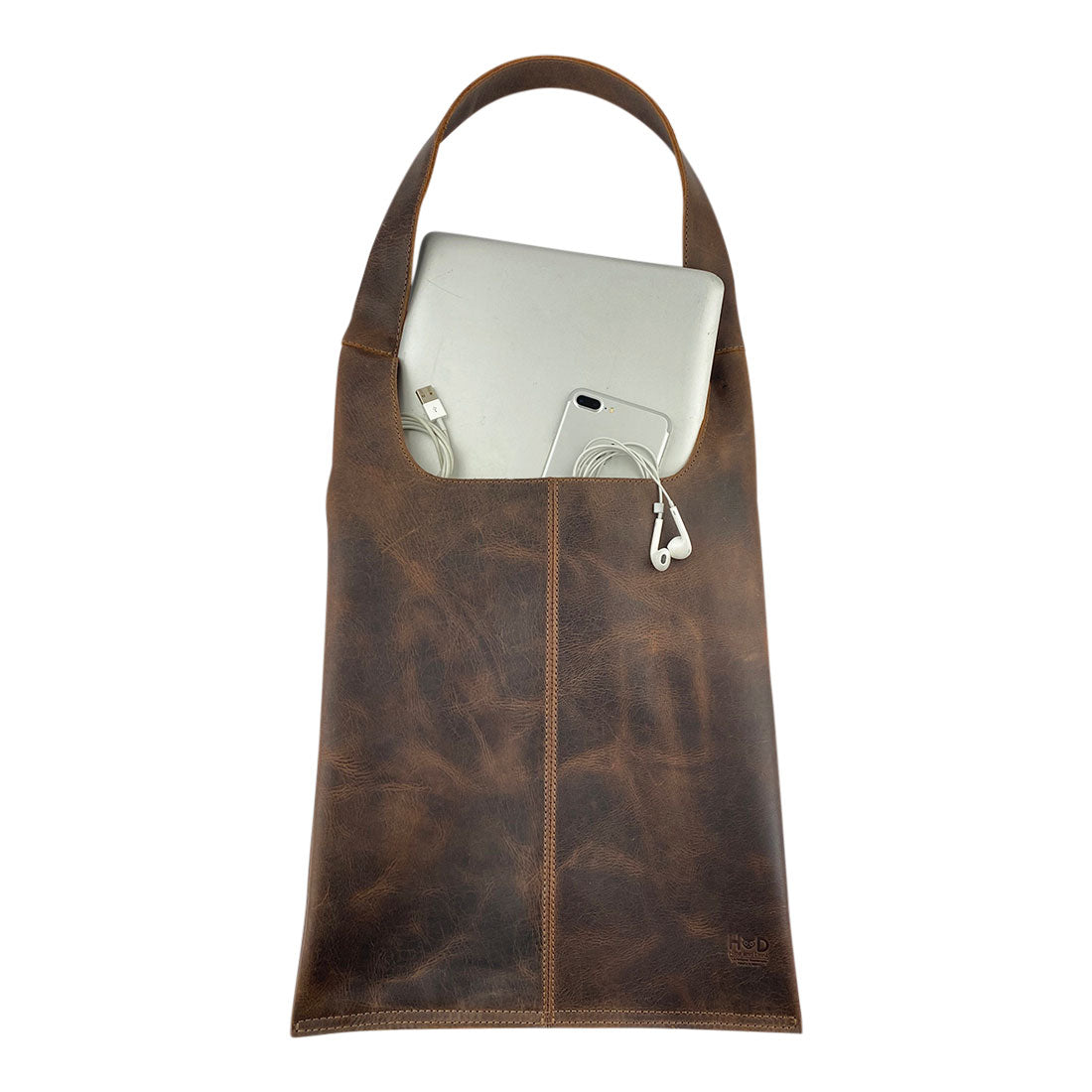 Shoulder Bag for Laptop by Hide & Drink with a laptop and phone, showcasing its practical design for modern travelers. Made from high-quality full grain leather, this bag is hand cut and sewn by artisans in La Antigua Guatemala.