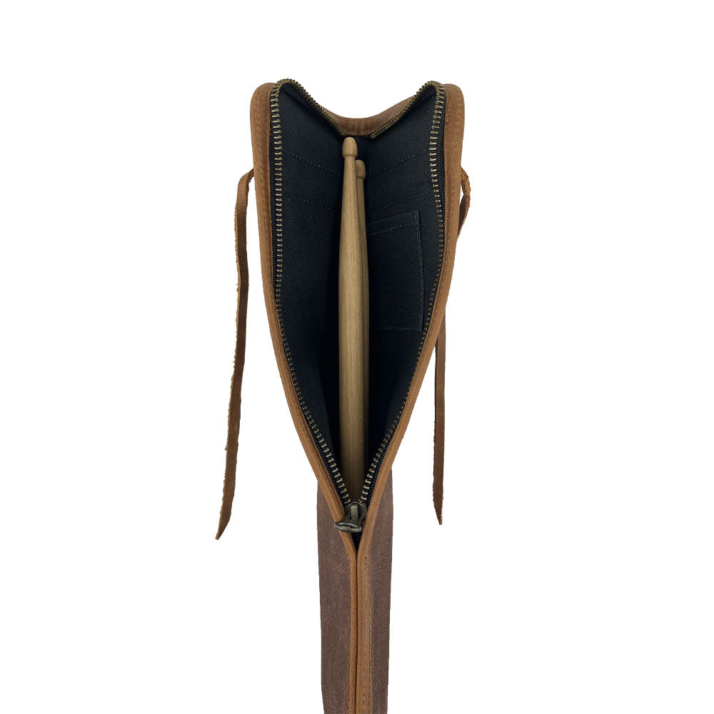 The brown Hide & Drink Drummstick Bag displayed with drumsticks, emphasizing its design and functionality. This durable Waxed Canvas & Full Grain Leather Drumstick Bag Holder is essential for musicians, reflecting small batch production values and artisan expertise from La Antigua Guatemala & Oaxaca Mexico.