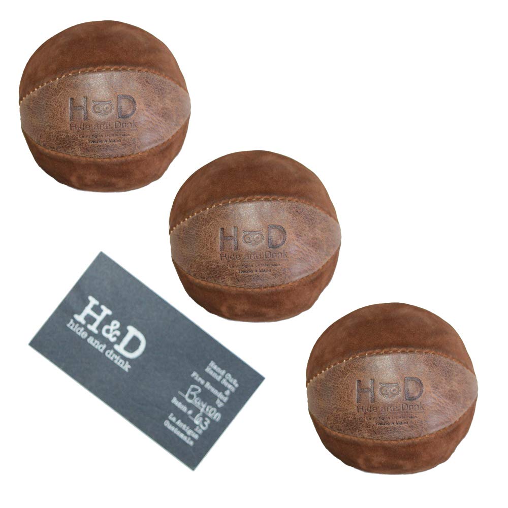 Hide & Drink Leather Juggling Balls (3-Pack) with product tag showing craftsmanship details. Full Grain Leather Juggling Balls Set of 3, created through Small Batch Production, Hand Cut, Hand Sewn, and Fire Branded by Artisan artisans. Handmade in La Antigua Guatemala & Oaxaca Mexico.