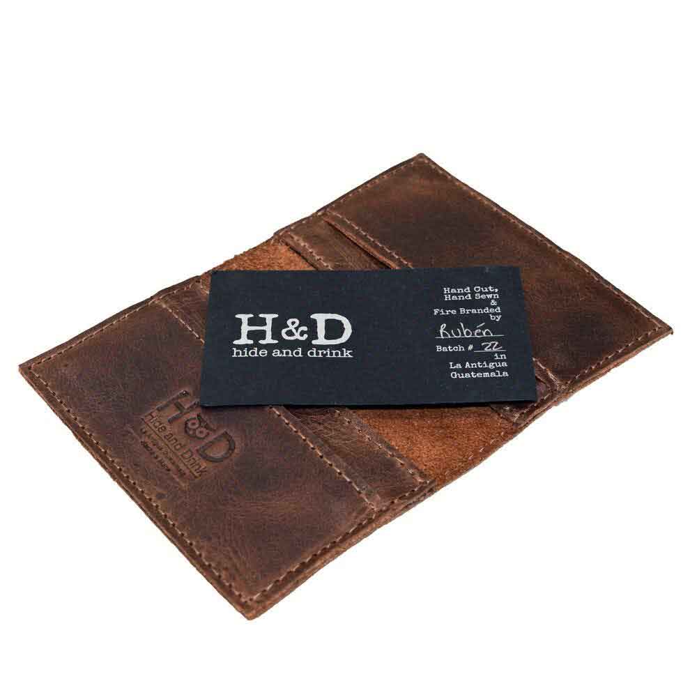 Inside view of Bifold Horizontal Card Wallet by Hide & Drink, featuring a business card tucked inside, ideal for a minimalist traveller wallet, organizer capable of holding up to 8 cards, made of durable full grain leather with emphasis on small batch production, hand cut, hand sewn, fire branded, and artisan craftsmanship, handmade in La Antigua Guatemala & Oaxaca Mexico.