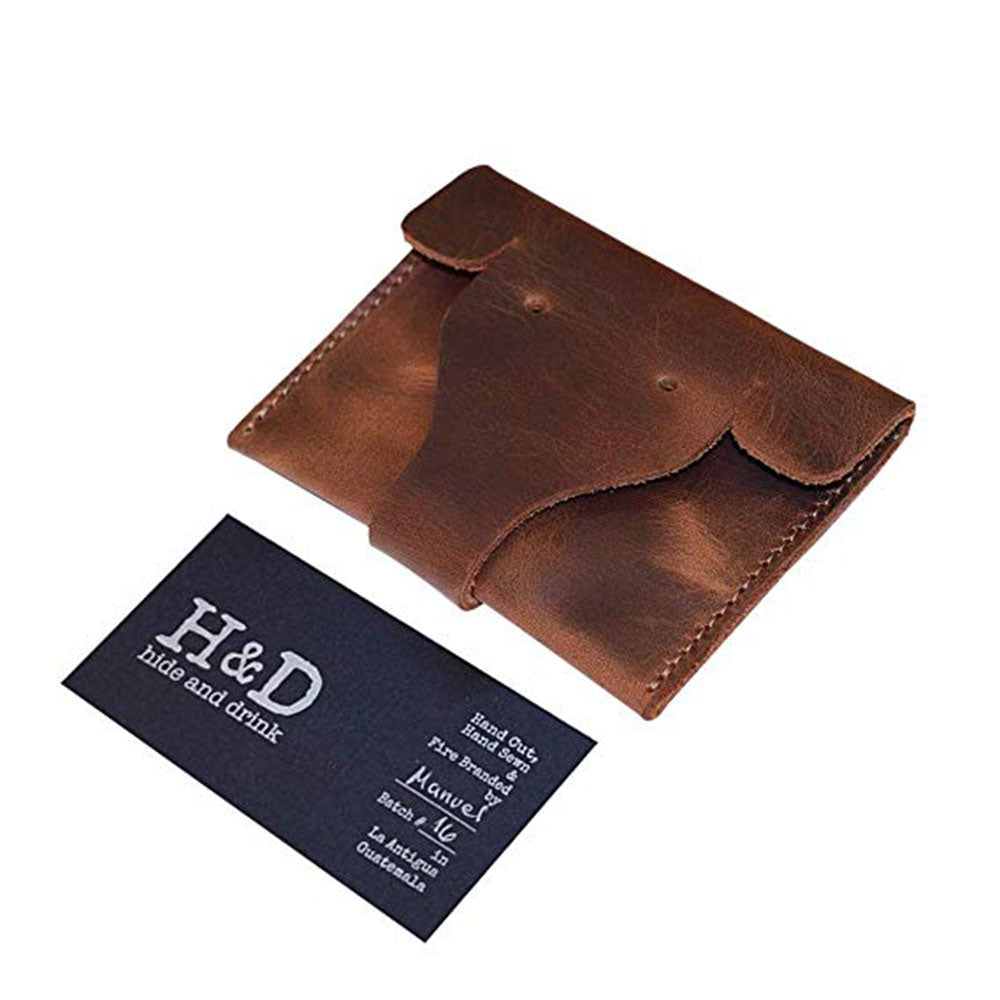 Elephant Coin Pouch by Hide & Drink alongside a business card, highlighting its compact and artistic design made from premium full grain leather. Card Pouch Elephant/Coin & Folded Bills/Wallet/Cable Holder/USB/SD/Change, Full Grain Leather, StockyardX, Hand Cut, Hand Sewn, Fire Branded, Artisan, Handmade in La Antigua Guatemala & Oaxaca Mexico.