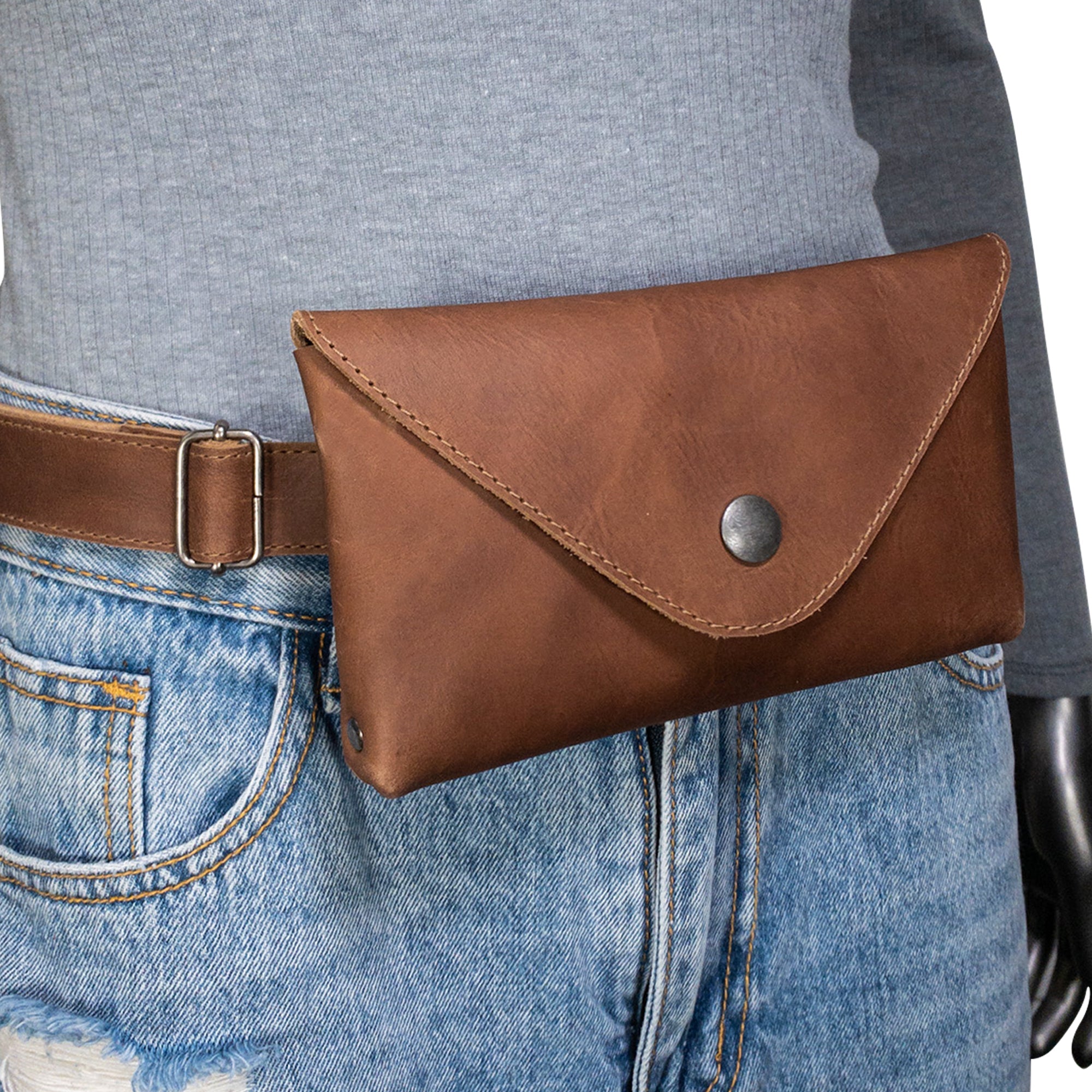 Model showcasing Hide & Drink's Fancy Fanny Pack in brown, demonstrating its usability as a stylish waist pouch. This full grain leather bag is great as a fanny pack or vintage purse, hand sewn with artisan quality in La Antigua Guatemala.