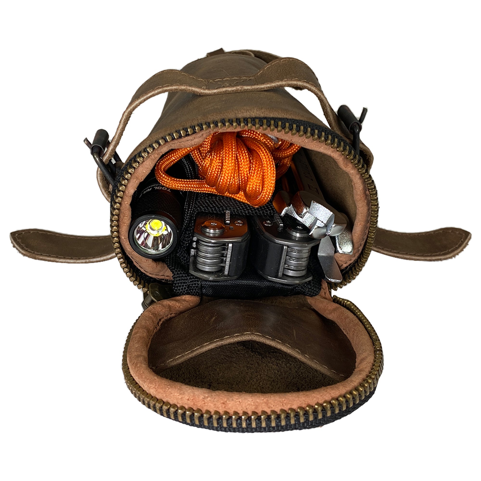 Open view of the Hide & Ride Under Seat Pouch displaying its spacious interior filled with accessories. This unique Bicycle Under Seat Pouch is an essential organizer for bikers looking for practicality. Crafted from full grain leather, it spotlights the small batch artisan creation in La Antigua Guatemala & Oaxaca Mexico.