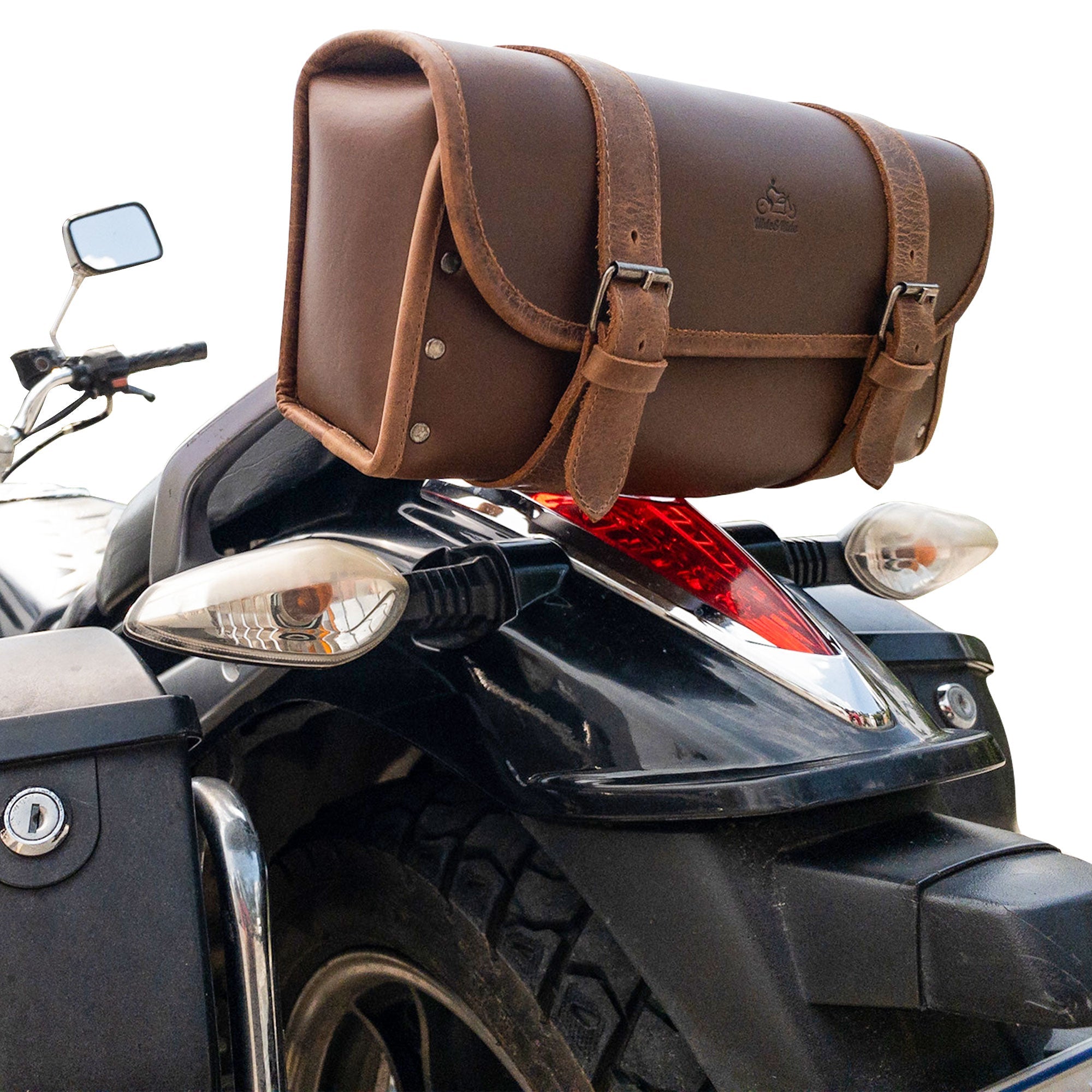Riveted Bag for Motorcycle by Hide & Ride displayed on a motorcycle, focusing on its secure placement and adjustable belts. This Motorcycle Riveted Bag is crafted from durable full grain leather and highlights the handmade quality from artisans in La Antigua Guatemala & Oaxaca Mexico.