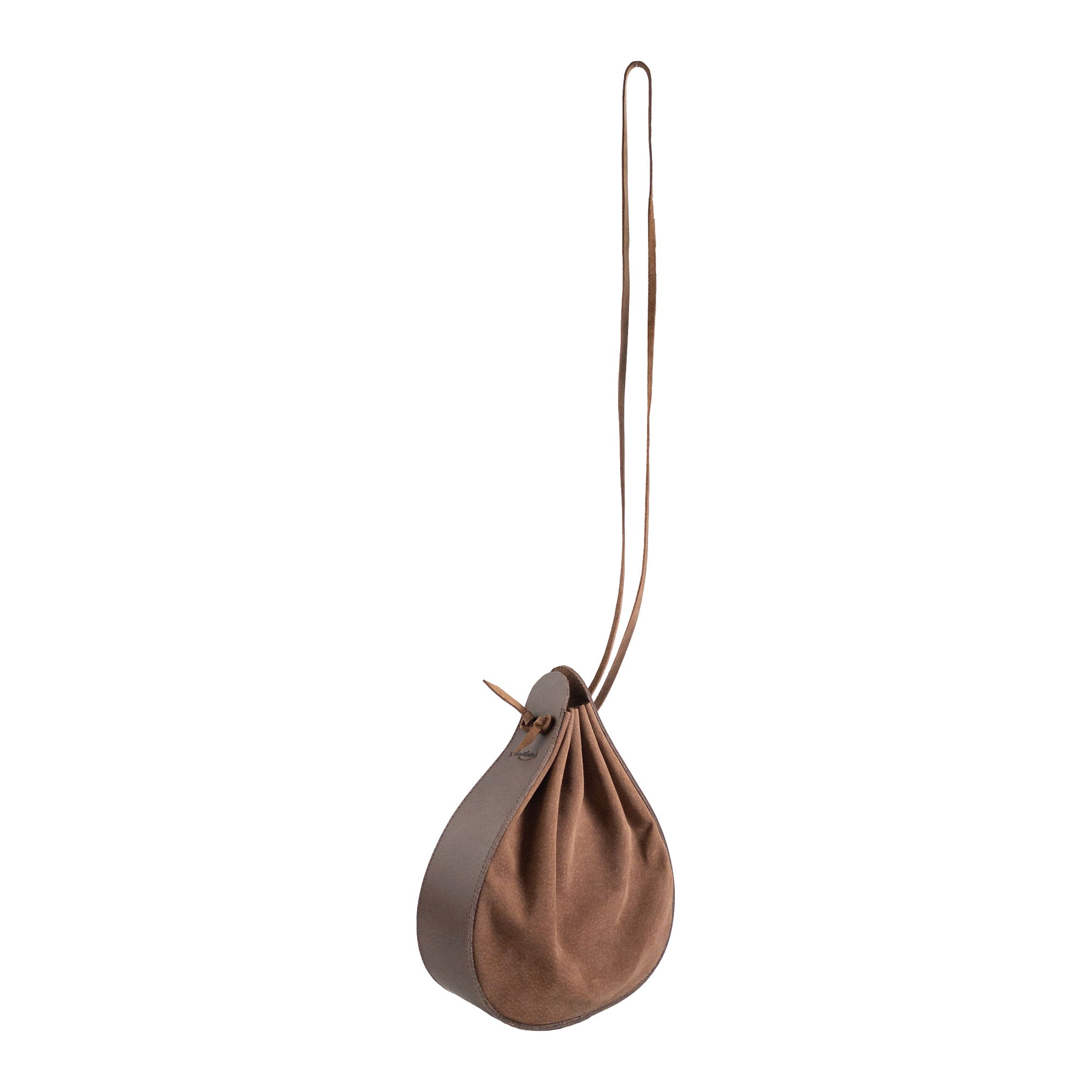 Heather's Shoulder Bag displayed in a creative angle, featuring its multipurpose rounded shape. This full grain leather shoulder bag is ideal for travel and reflects artisan quality through small batch production, hand cut and hand sewn craftsmanship, along with fire branding. Handmade in La Antigua Guatemala & Oaxaca Mexico.