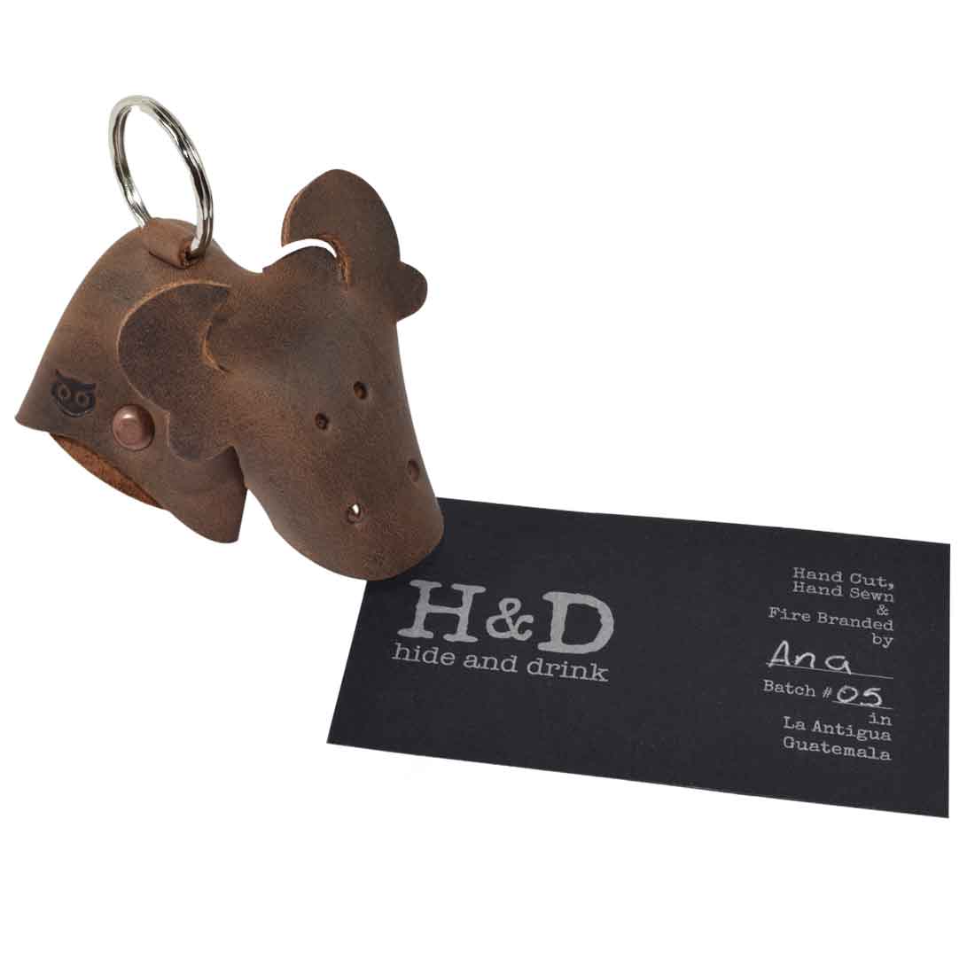 Unique Full Grain Leather Animal Key Chain by Hide & Drink showcasing a cow design along with a brand tag. This Critter Keychain is not only a fob charm but also an elegant animal key holder charm pendant, hand cut and sewn in small batches in La Antigua Guatemala.