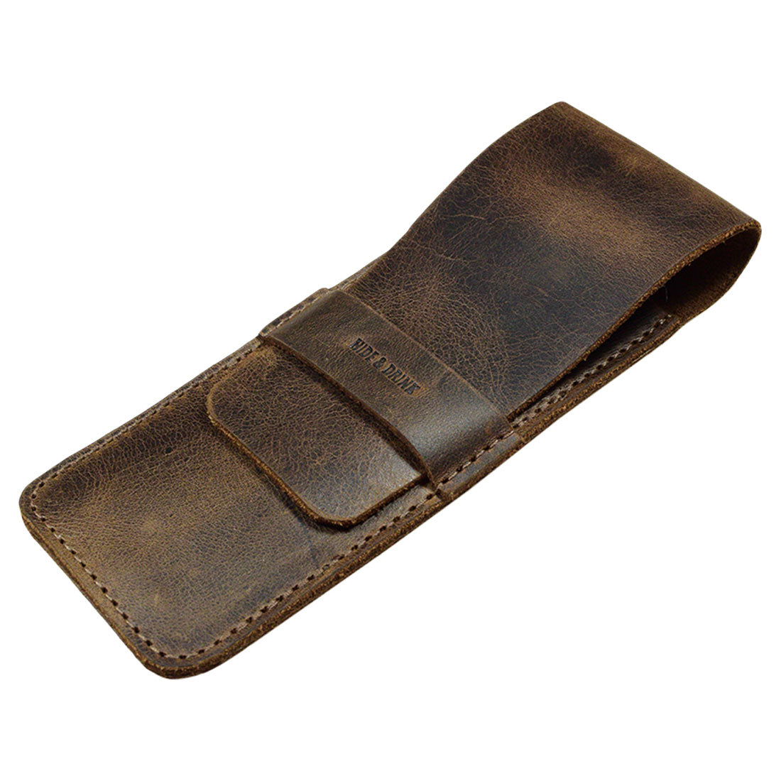 A closed Pen Case from Hide & Drink, featuring a sleek leather design. This Pen Case Holder is an excellent protective sleeve for your pens and is great as a Multi Pen Pouch. Created from resilient Full Grain Leather, it represents the values of StockyardX, focusing on small batch production. Each piece is meticulously hand cut and hand sewn, with a fire branded logo that exemplifies artisan skills, handmade in La Antigua Guatemala & Oaxaca Mexico.