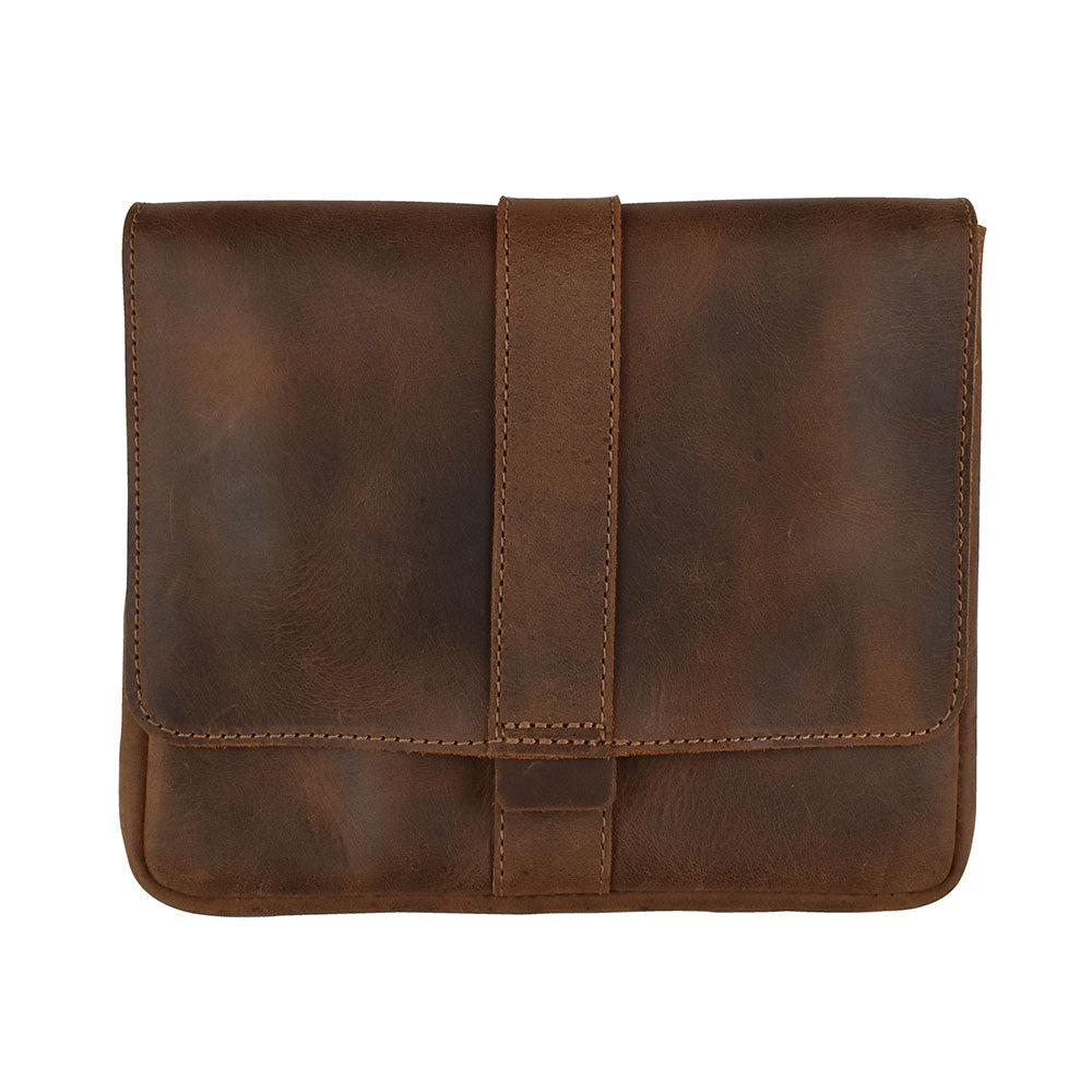 Front view of the Kindle Oasis Sleeve by Hide & Drink, closed and secured with a strap, made of durable full grain leather. This sleek travel accessory serves as a Tablet Sleeve and Protector Cover, handcrafted in La Antigua Guatemala & Oaxaca Mexico.