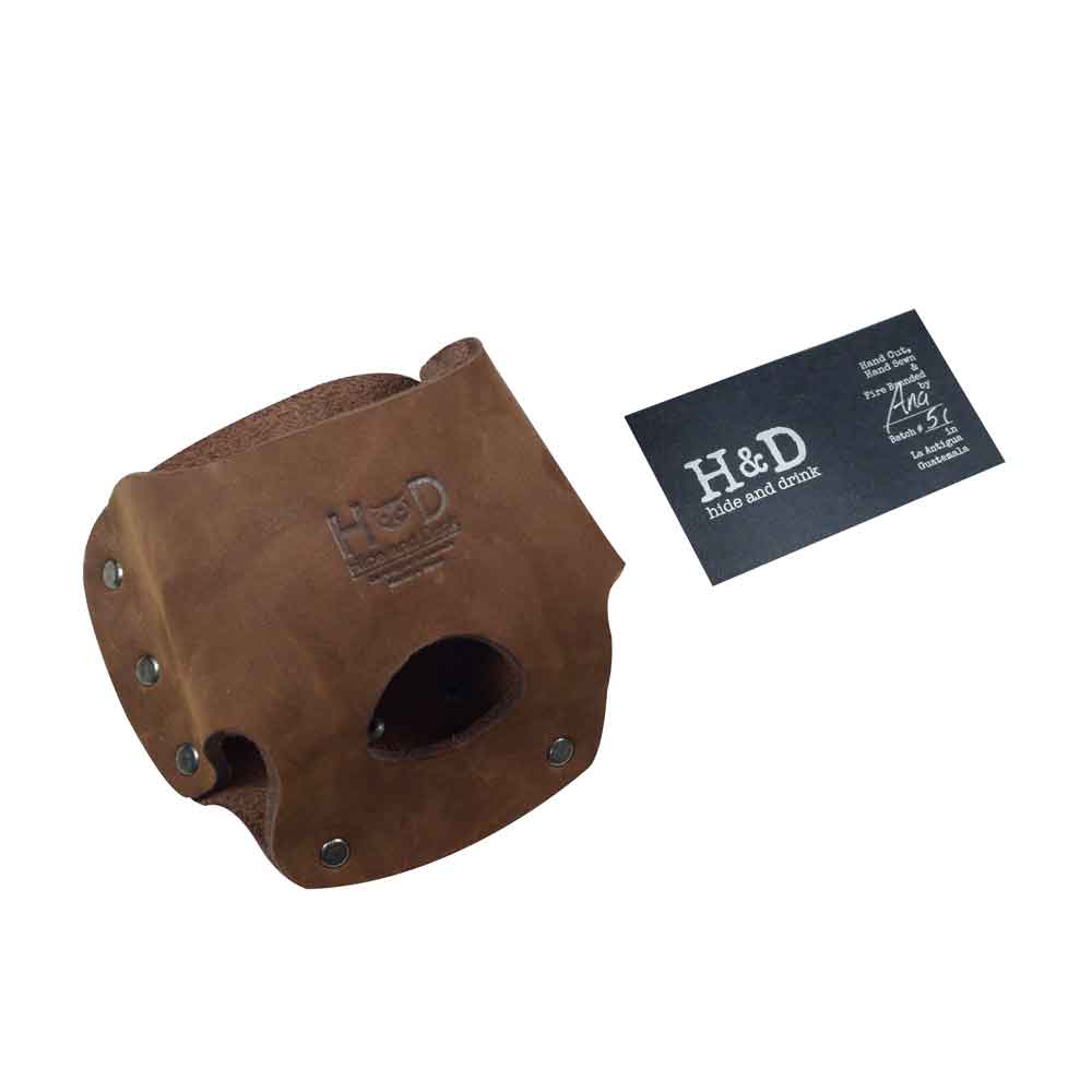 Hide & Drink's red Large Tape Holster next to a branding card, showcasing its crafted quality. Ideal for handymen looking for a durable tool holster.