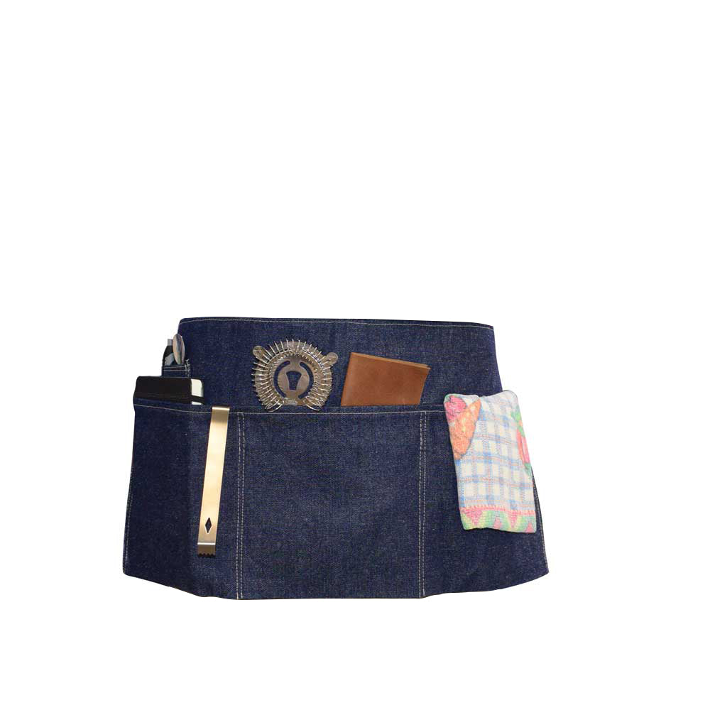 Hide & Drink's Repurposed Denim Waist Apron filled with kitchen essentials, demonstrating its practicality and style. This handmade waist apron, crafted with Full Grain Leather in La Antigua Guatemala & Oaxaca Mexico, features artisanal details with small batch production, hand sewn and cut segments.