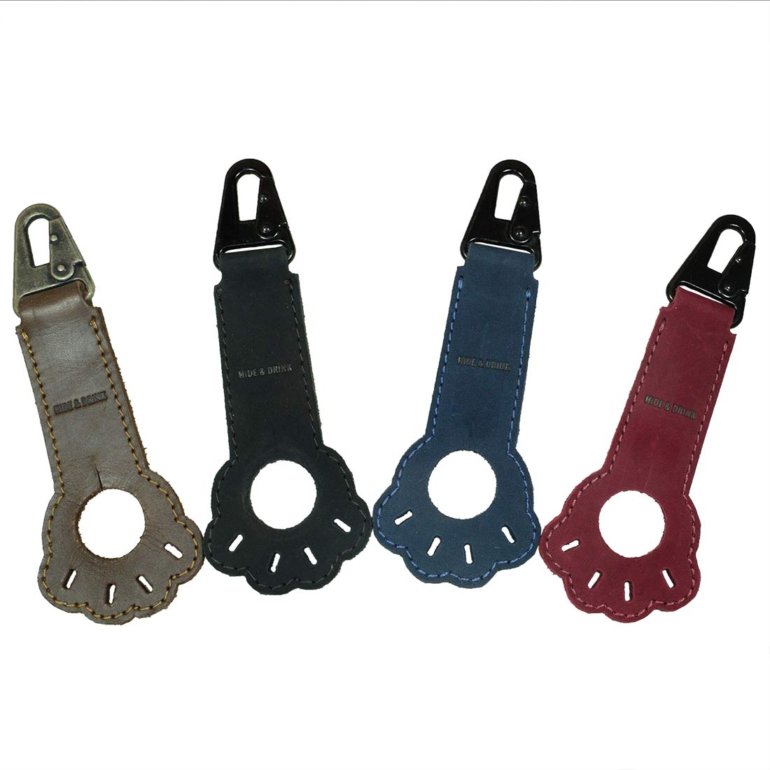 Collection of thick full grain leather Paw Bottle Holders by Hide & Drink in various colors, ideal for dog lovers. Each handmade piece serves as a belt holder and travel essential, demonstrating artisan quality from small batch production.