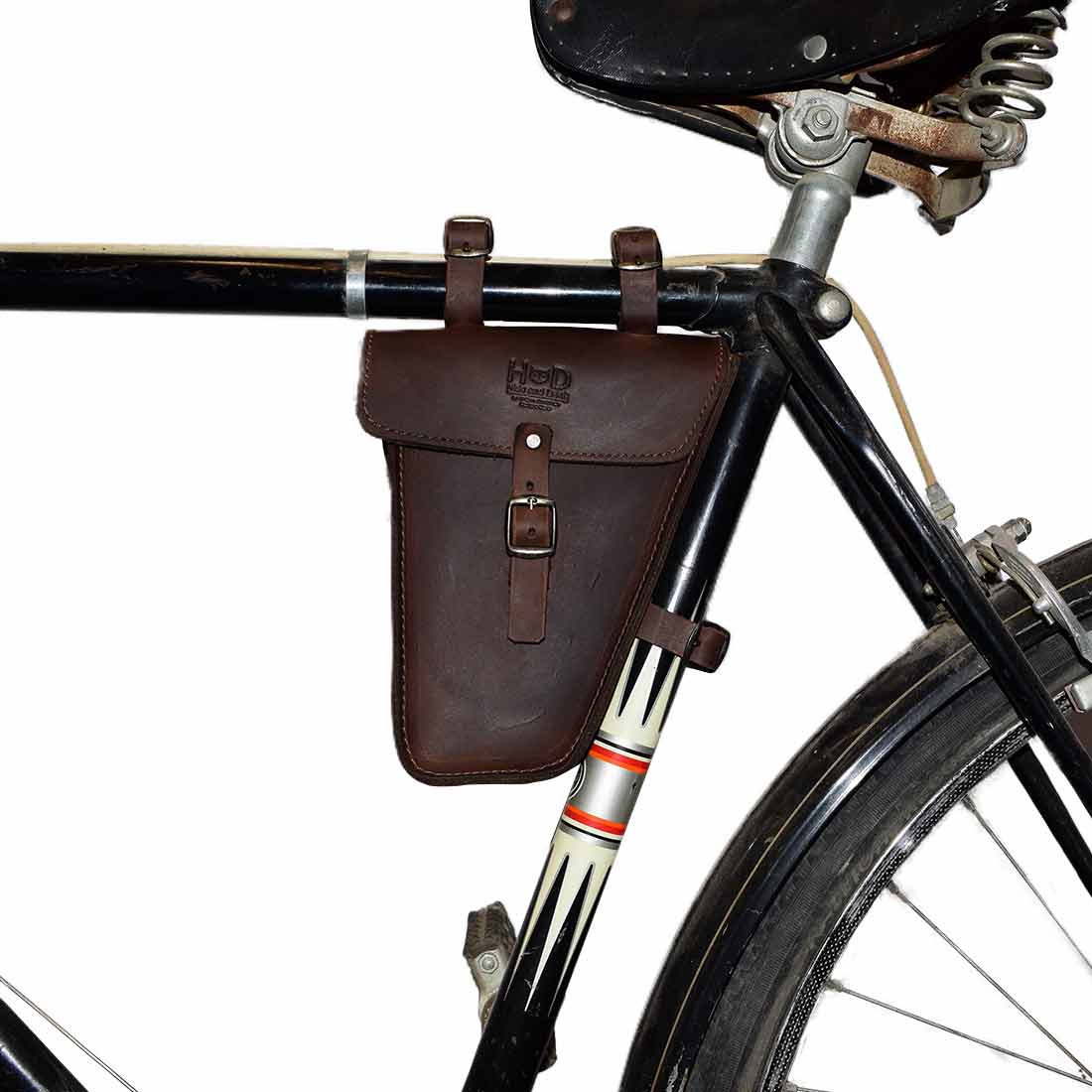 Hide & Drink's Frame Bag For Bicycle showcased on a bike, ideal for storing repair tools. This Triangular Frame Bag for Bicycle is a perfect accessory for bikers, crafted from Full Grain Leather and handmade in La Antigua Guatemala & Oaxaca Mexico. It‚Äôs a great tool pouch for storing bike essentials, featuring small batch production and artisan craftsmanship.